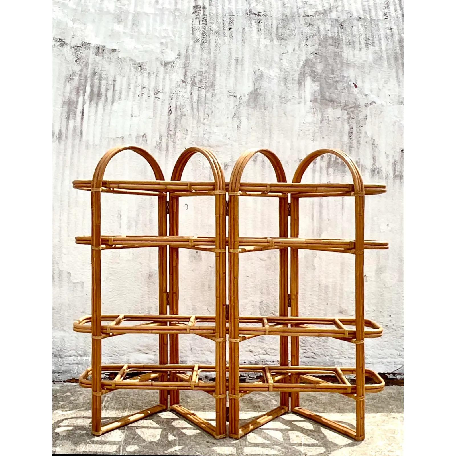 Fantastic vintage coastal etagere. A chic solid rattan frame in a folding design. Panel rattan shelves rest on to the frame. Inset glass shelves. Acquired from a Palm Beach estate.