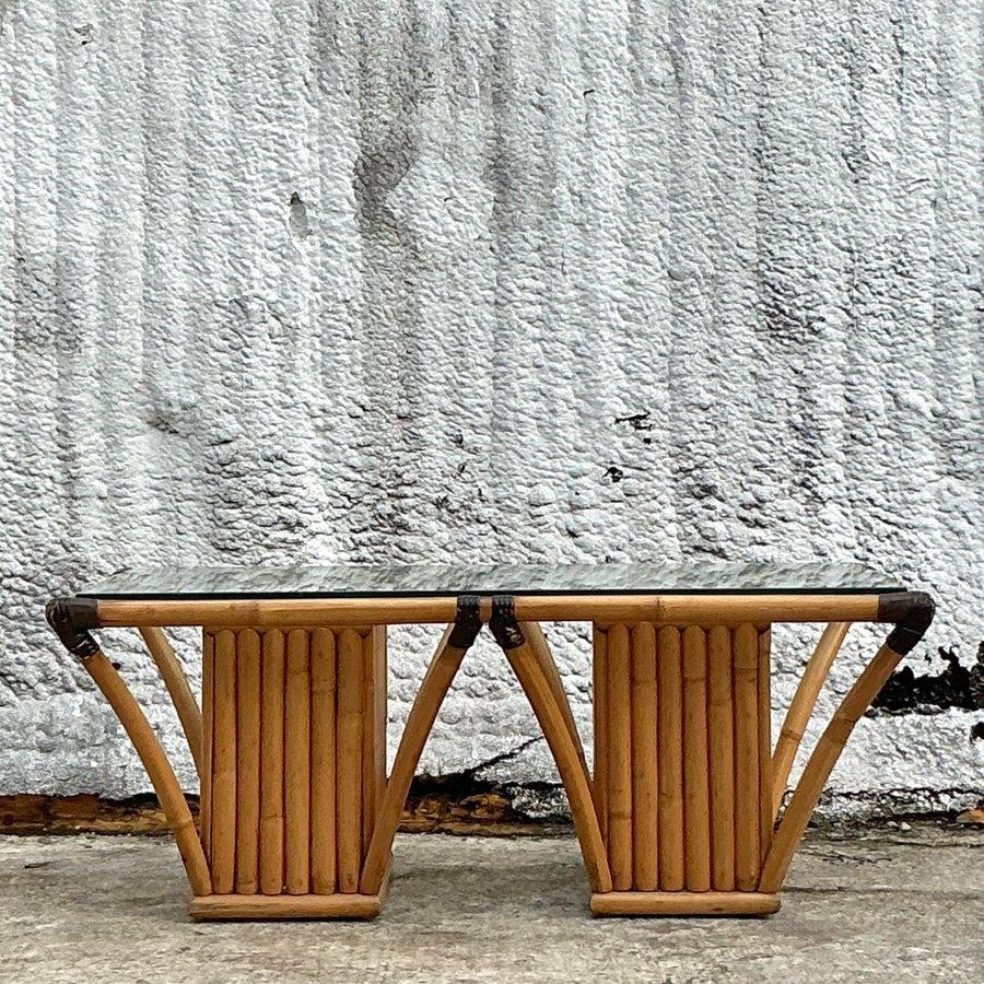Apportez une élégance décontractée à votre espace de vie avec cette table basse vintage à cadre en rotin côtier. Dotée d'un cadre en rotin magnifiquement travaillé avec des accents naturels tissés, cette table capture l'essence de la vie en bord de