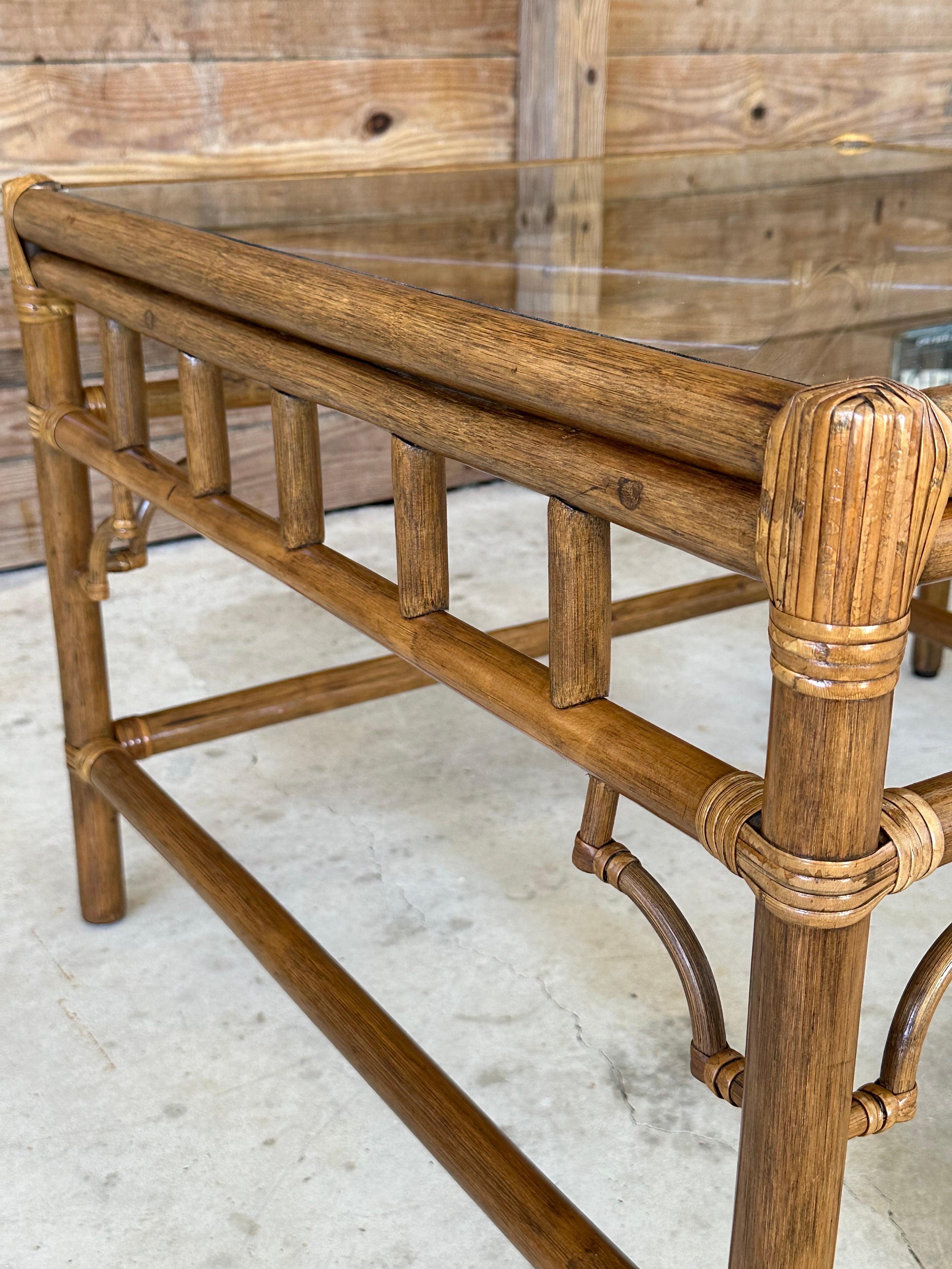 This pair of vintage coastal side tables features rattan fretwork in the classic Chippendale style with new glass added. The inlay tops add a touch of refinement, combining traditional craftsmanship with coastal charm, making them perfect accent