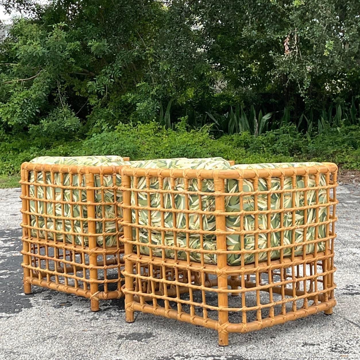 A fantastic pair of vintage Coastal lounge chairs. A chic rattan frame in a grid design. Done in the manner of Henry Olko for Willow and Reed. Coordinating sofas and ottoman also available on my page. Acquired from a Palm Beach estate.