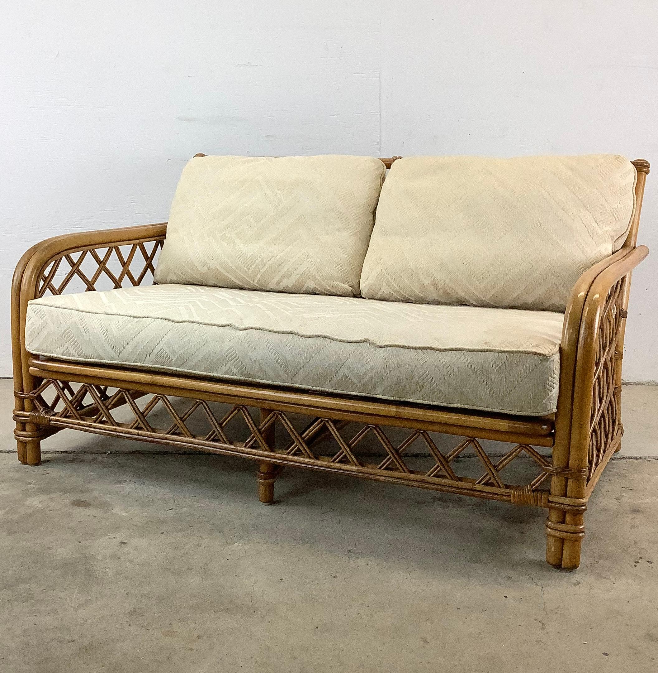 Step into a world of timeless elegance with this Vintage Coastal Rattan Loveseat by Ficks Reed. This exquisite piece, with its enchanting blend of classic design and coastal charm, is a true treasure for any interior. The loveseat's frame, expertly