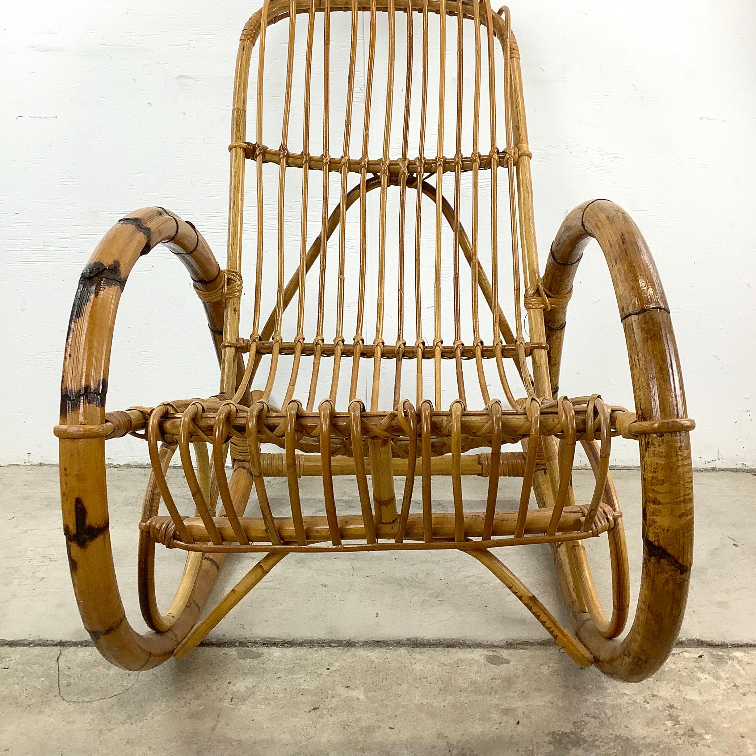 Kuscheln Sie sich in die nostalgische Umarmung dieses Rattan-Schaukelstuhls im Vintage-Stil von Franco Albini, ein Stück, das an gemütliche Nachmittage und zeitlosen Komfort erinnert. Dieser wunderschön gearbeitete Stuhl mit seinem natürlichen
