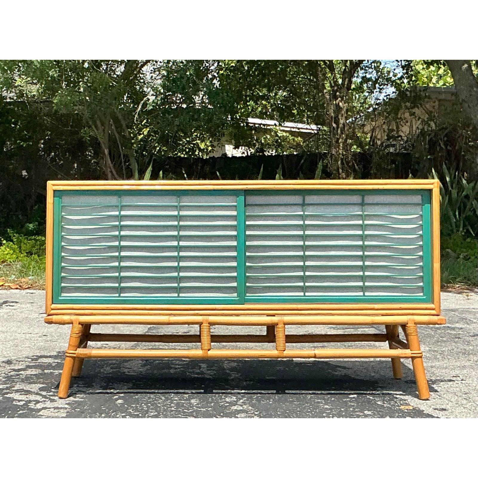 Capture the essence of relaxed, tropical elegance with this striking Vintage Rattan Sideboard, beautifully crafted in the coveted style of Ficks Reed. Its warm wood tones are perfectly complemented by an intricately wrapped rattan base and