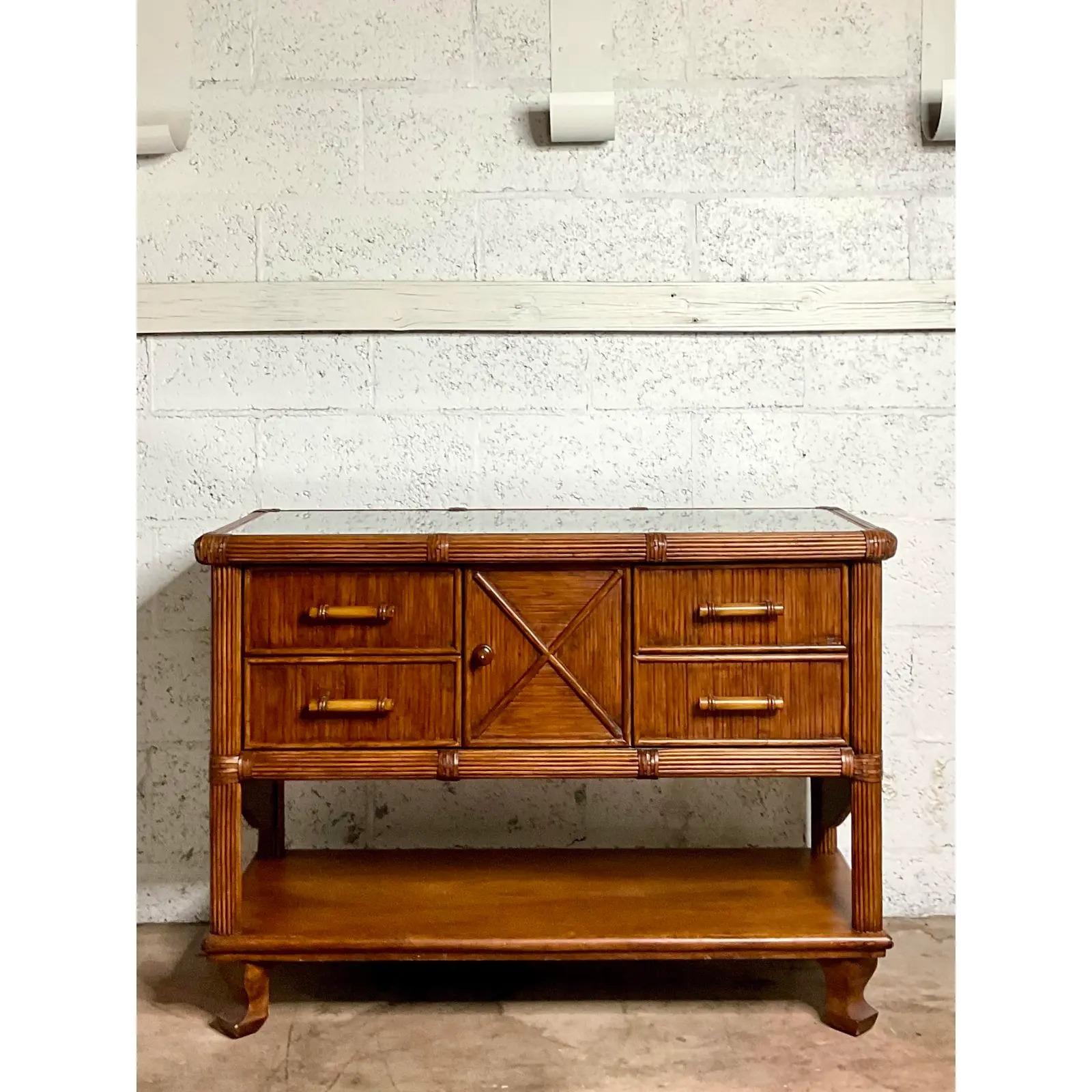 Gorgeous vintage Coastal sideboard. Beautiful deep brown rattan in a classic design. Inset glass top. Acquired from a Palm Beach estate.