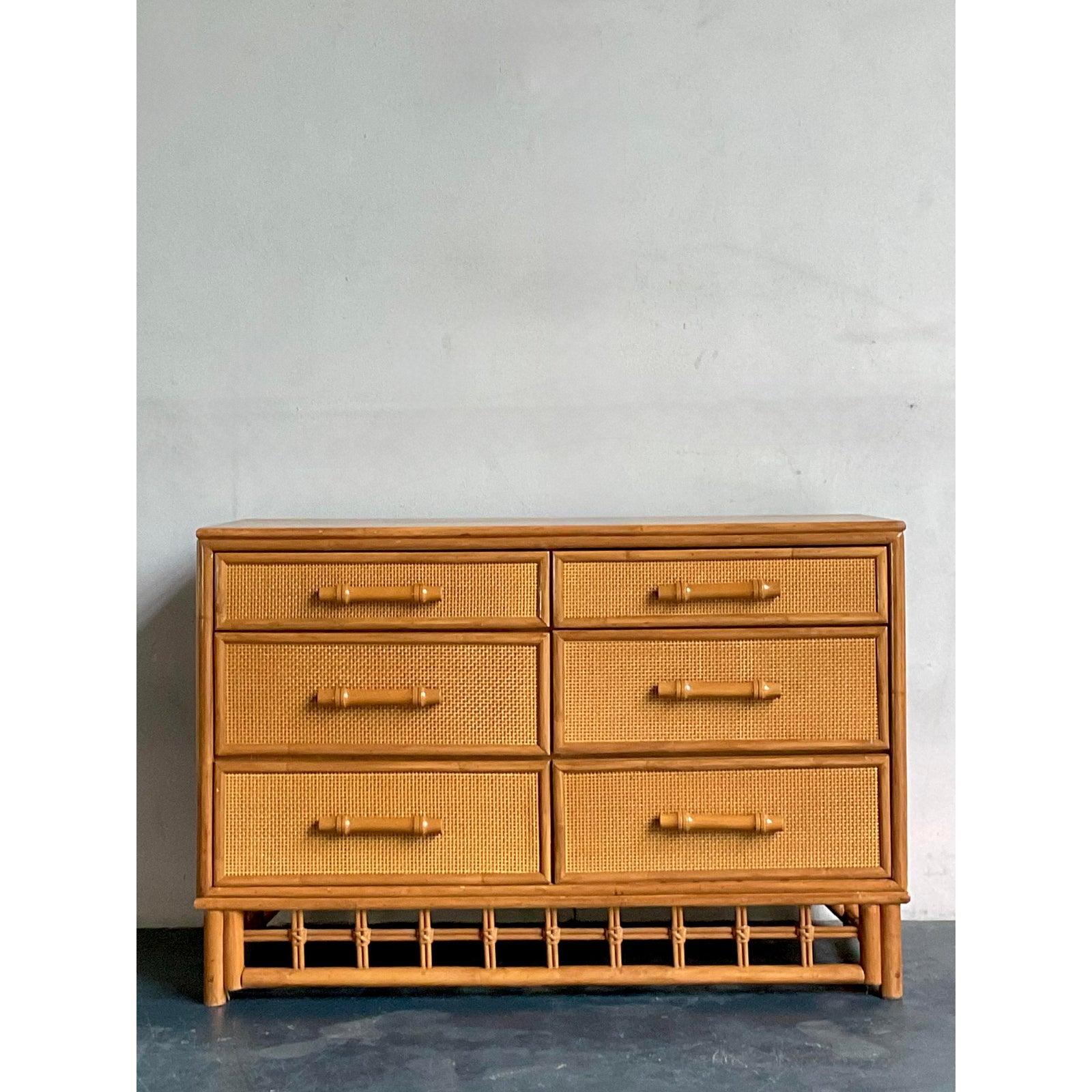 Questo affascinante comò vintage a sei cassetti emana una deliziosa estetica costiera e boho-chic, perfetta per aggiungere calore e consistenza a qualsiasi interno. Realizzato in rattan naturale e caratterizzato da bellissimi cassetti in canna