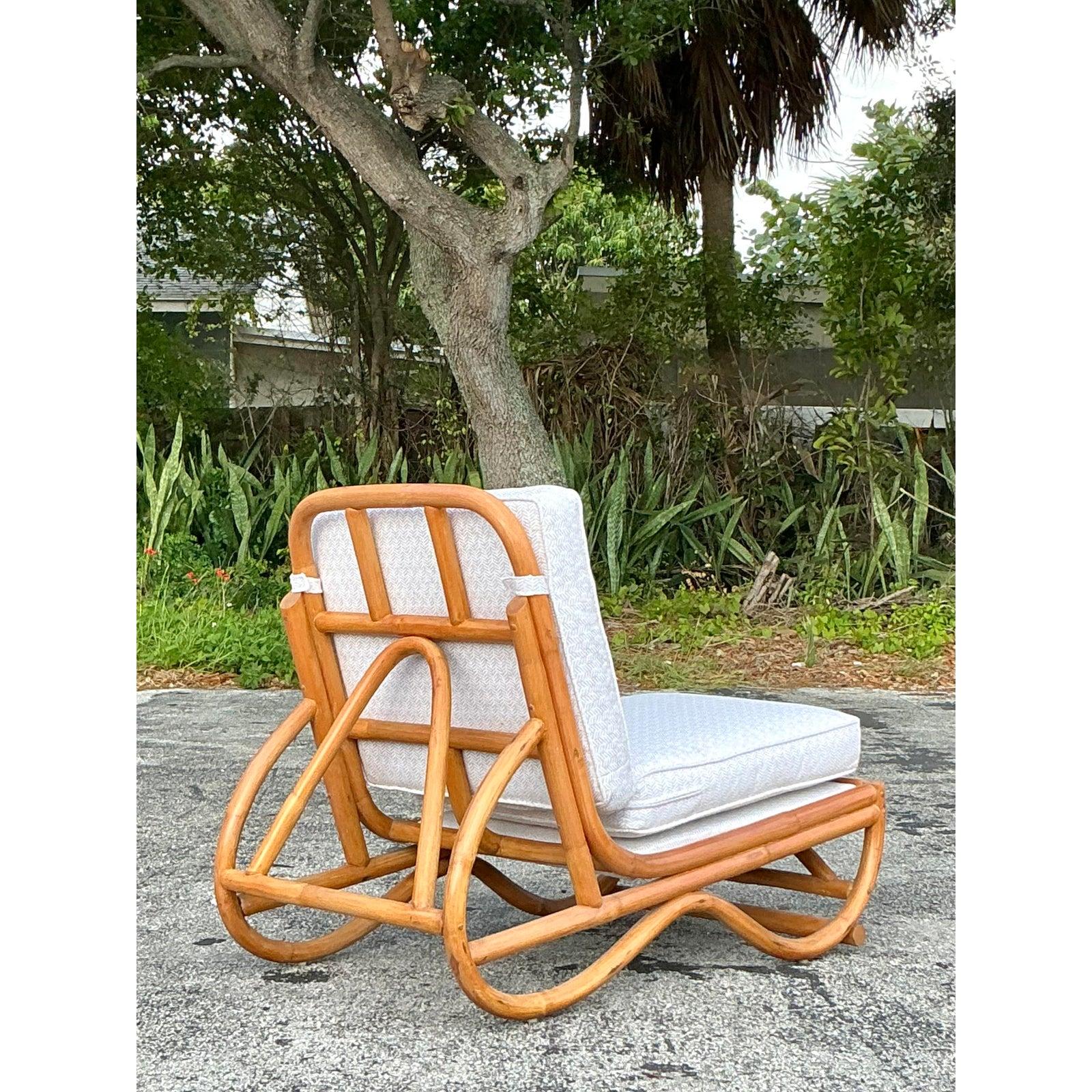 This vintage coastal rattan slipper chair embodies effortless tropical elegance with its beautifully sculptural frame and natural woven appeal. Designed with a striking bentwood silhouette, this chair showcases the artistry of handcrafted rattan