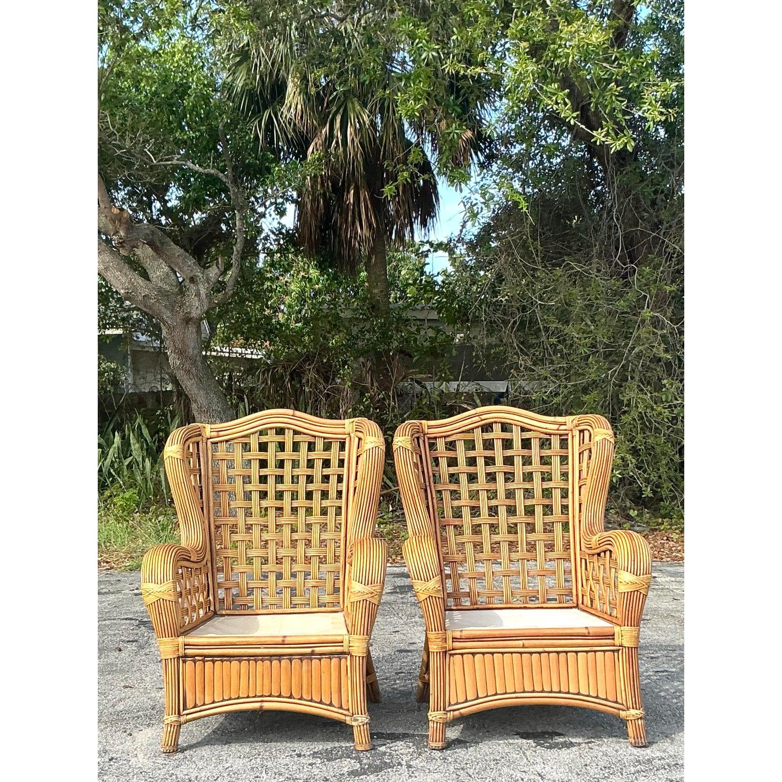 Peppen Sie Ihren Raum mit diesem atemberaubenden Paar Rattan-Wingback-Sessel im Vintage-Stil auf. Diese kunstvoll geflochtenen Stühle zeichnen sich durch ein luftiges, offenes Geflecht aus, das fachmännische Handwerkskunst und eine natürliche,