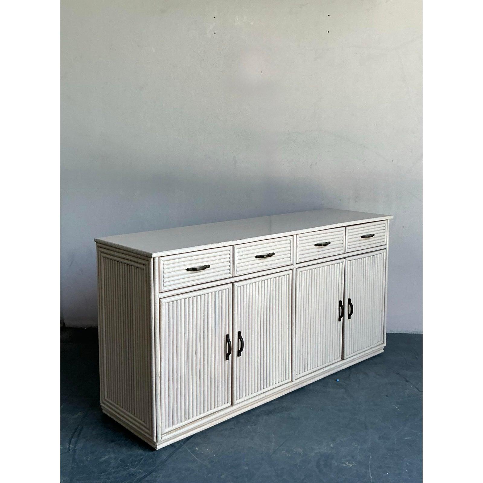 Bring timeless coastal charm into your home with this vintage reed credenza. Featuring beautifully textured reed-wrapped drawer and door fronts, this piece offers a sophisticated balance of natural craftsmanship and refined design. The light-toned