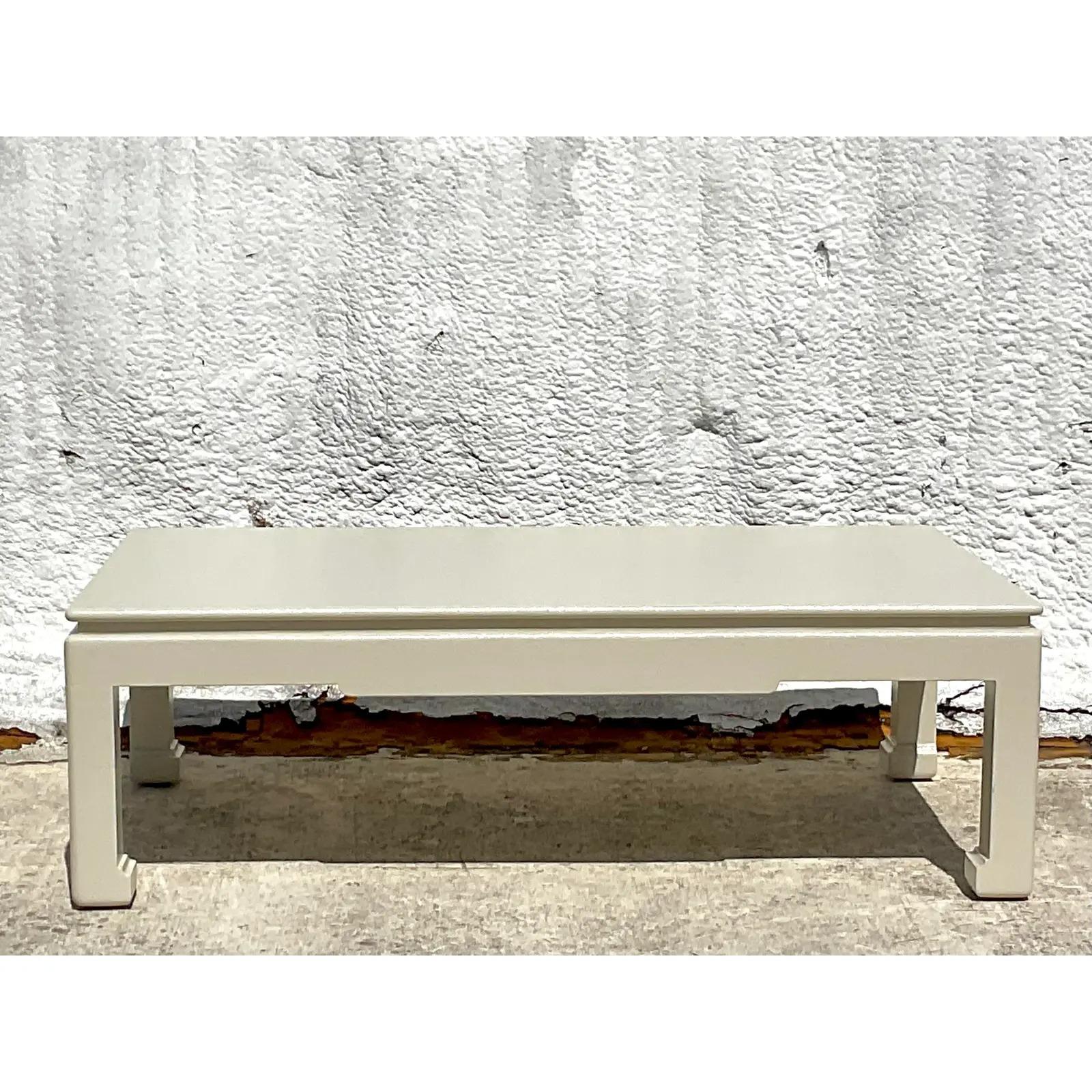 An exceptional vintage Regency Grasscloth coffee table. A large and impressive design done in the manner of Karl Springer. A chic wrapped Grasscloth in a semigloss painted finish. Ming legs and a groves top. Acquired from a Palm Beach estate.