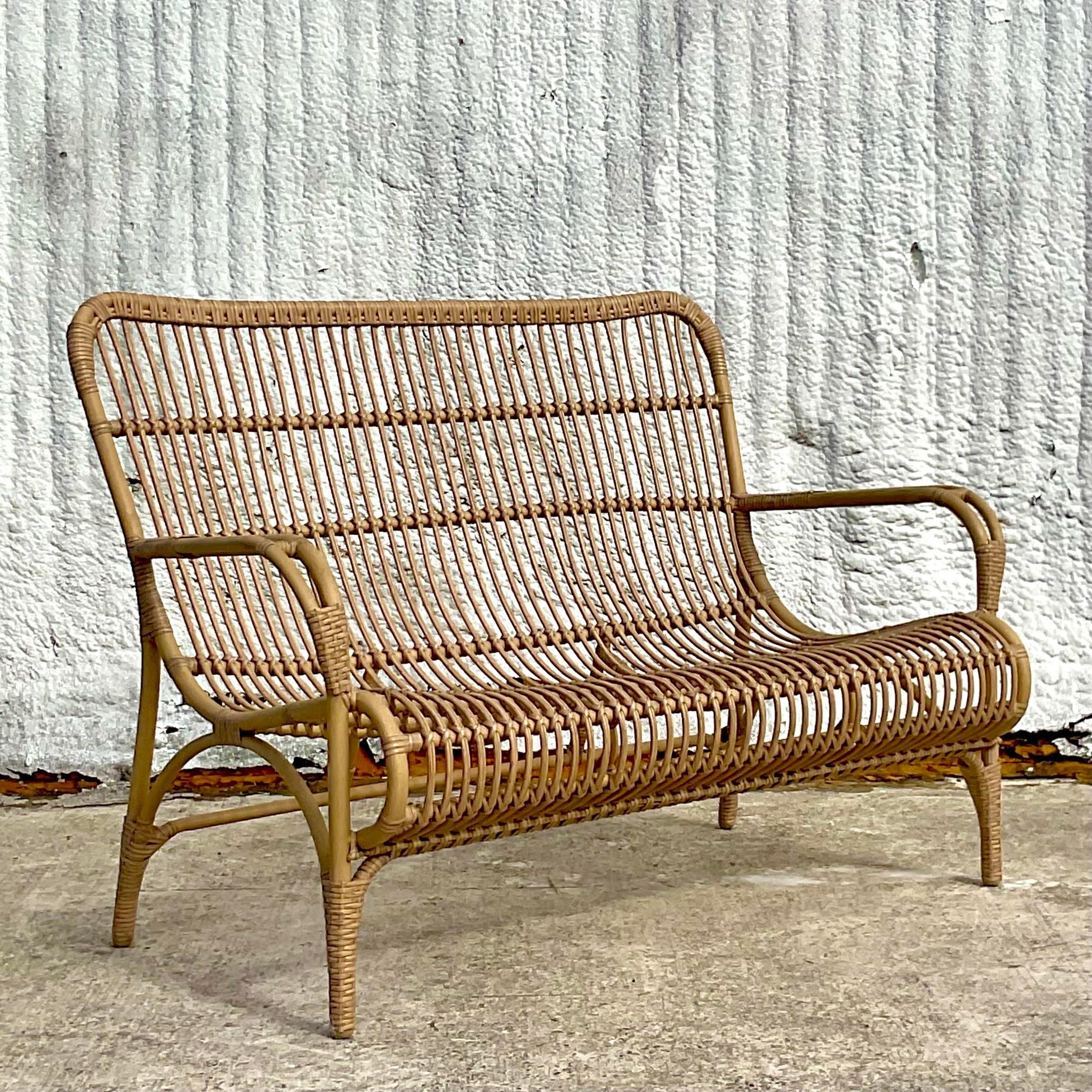 A fabulous vintage Coastal resin rattan loveseat. A chic open weave over an aluminum frame. The perfect piece for a high traffic area indoors or outside in a covered space. Acquired from a Palm Beach estate.