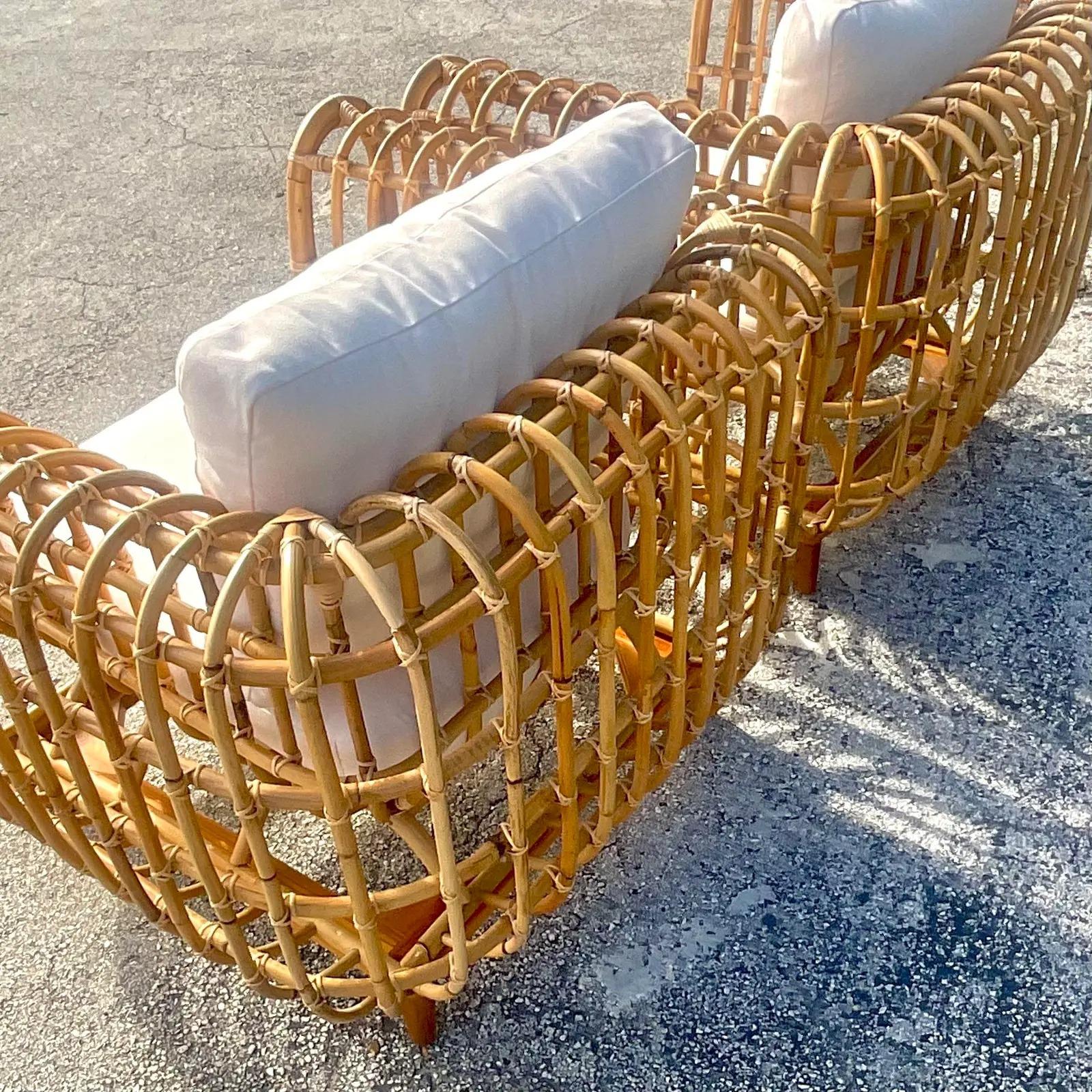 An incredible pair of Contemporary Coastal lounge chairs. Done in the manner of Henry Olko for Willow And Reed, with his signature ribbed design. A pair of bright white cushions for each chair. Acquired from a Palm Beach estate.