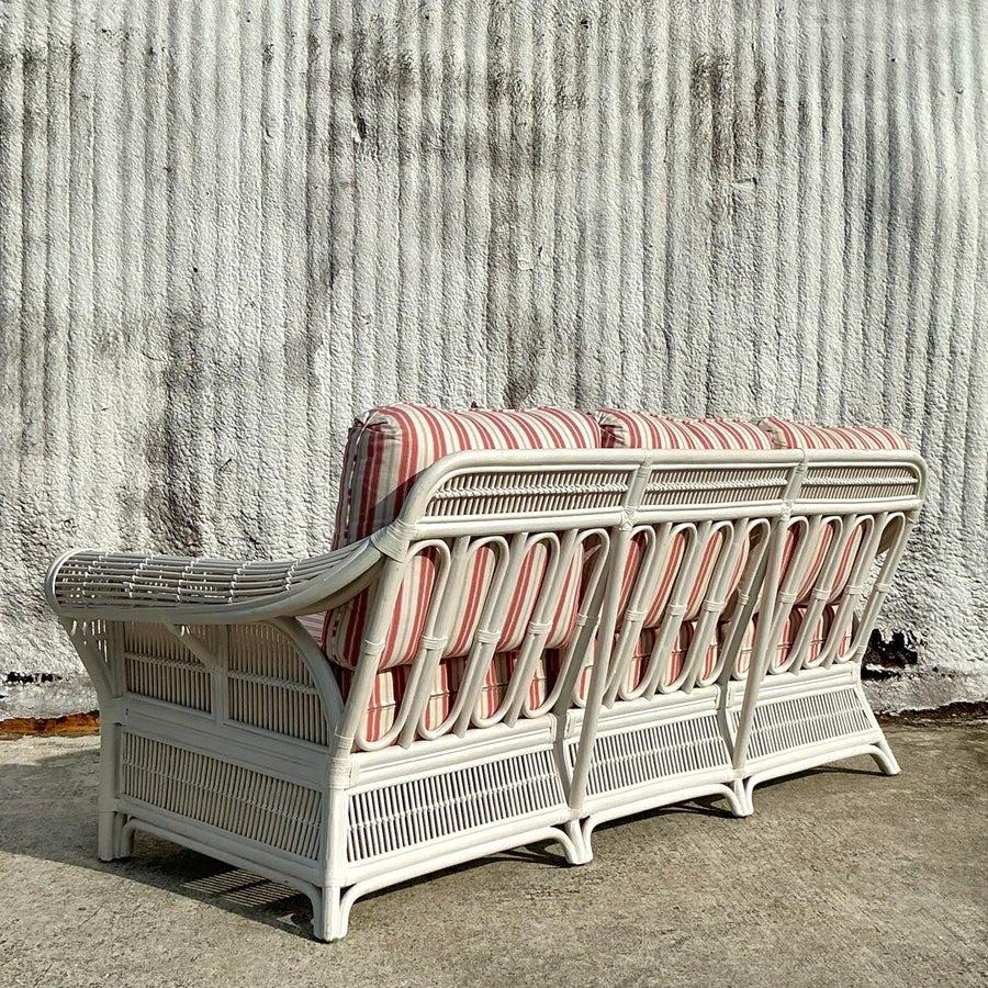Porta l'eleganza costiera nel tuo spazio abitativo con questo divano vintage in rattan con bracci a rotelle. Caratterizzata da una robusta struttura in rattan con braccioli splendidamente curvi e una finitura naturale, cattura il fascino senza tempo