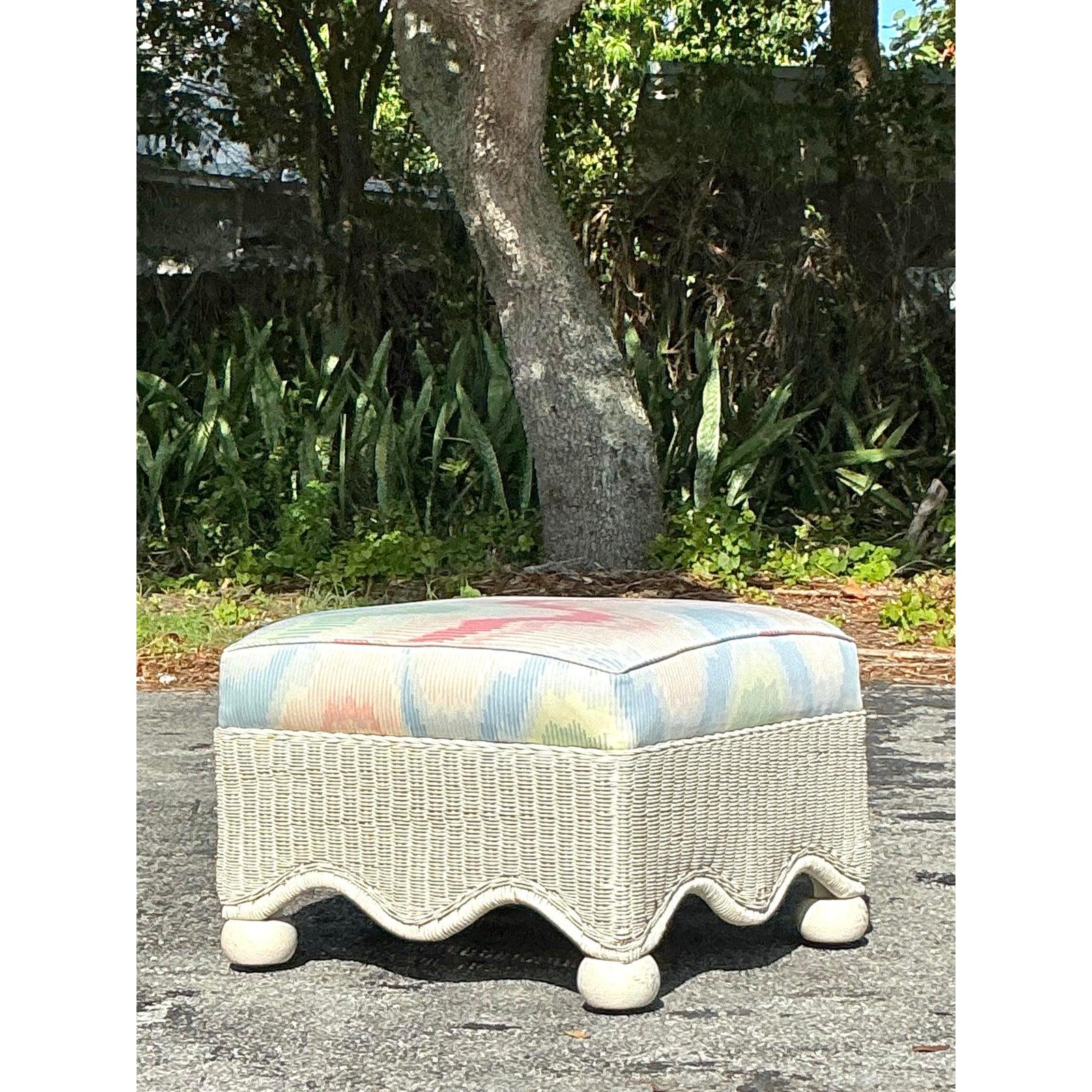 Cet ottoman en rotin vintage, inspiré des designs emblématiques de Ficks Reed, apporte à votre intérieur une élégance ludique et des vibrations côtières. Avec sa base en rotin tressé joliment festonnée et ses pieds en chignon fantaisistes, cette