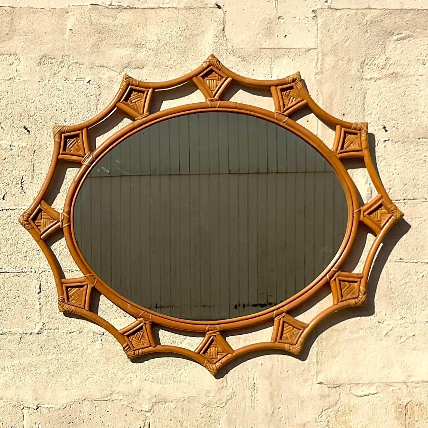 A fabulous vintage Coastal wall mirror. A chic scalloped rattan with inset wrapped rattan joints. Acquired from a Palm Beach estate.