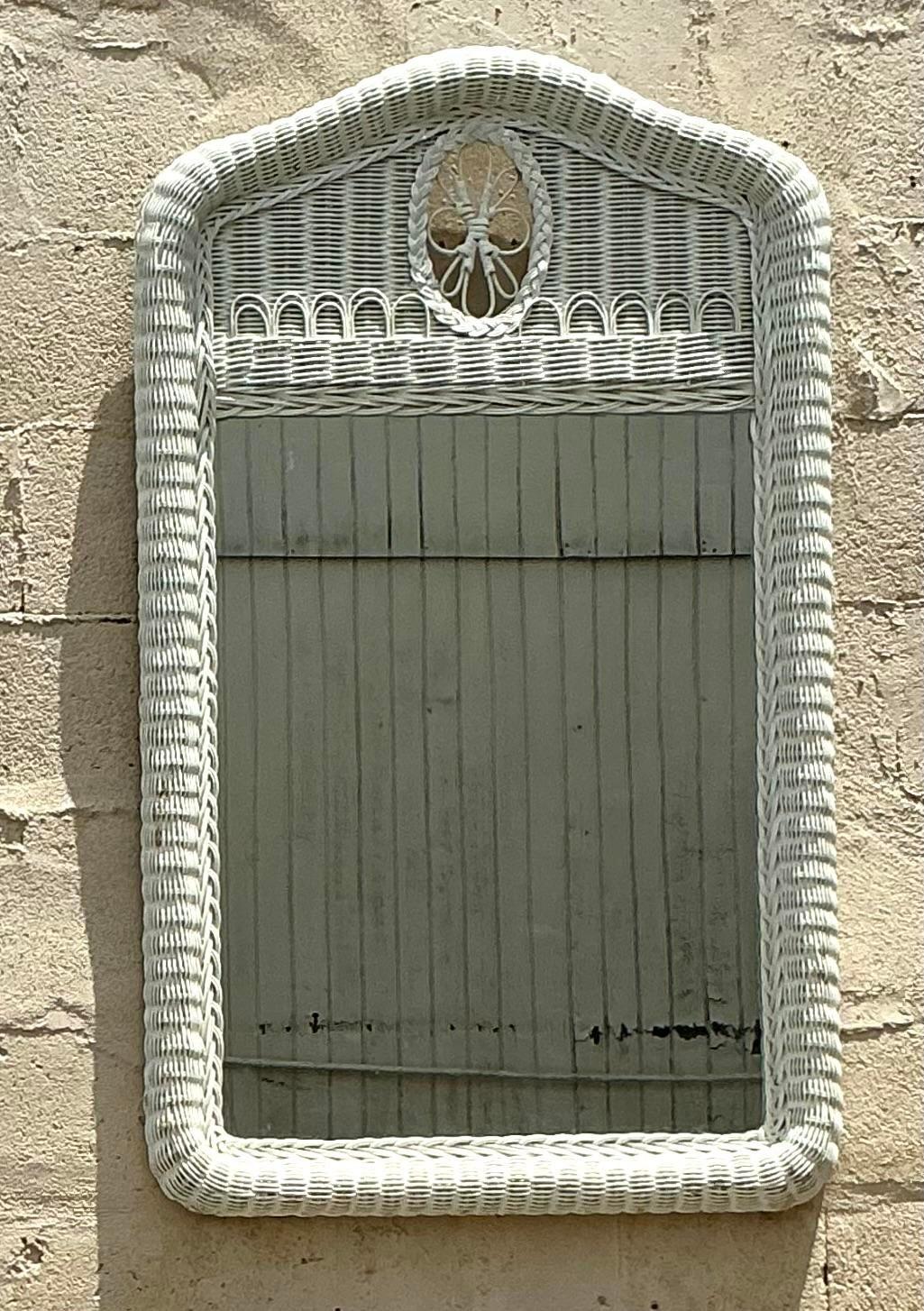 Nous vous présentons notre miroir vintage en rotin tissé festonné d'inspiration côtière : un ajout étonnant à tout décor d'inspiration côtière. Ce miroir présente un design festonné unique, encadré de rotin tressé de manière complexe pour un aspect
