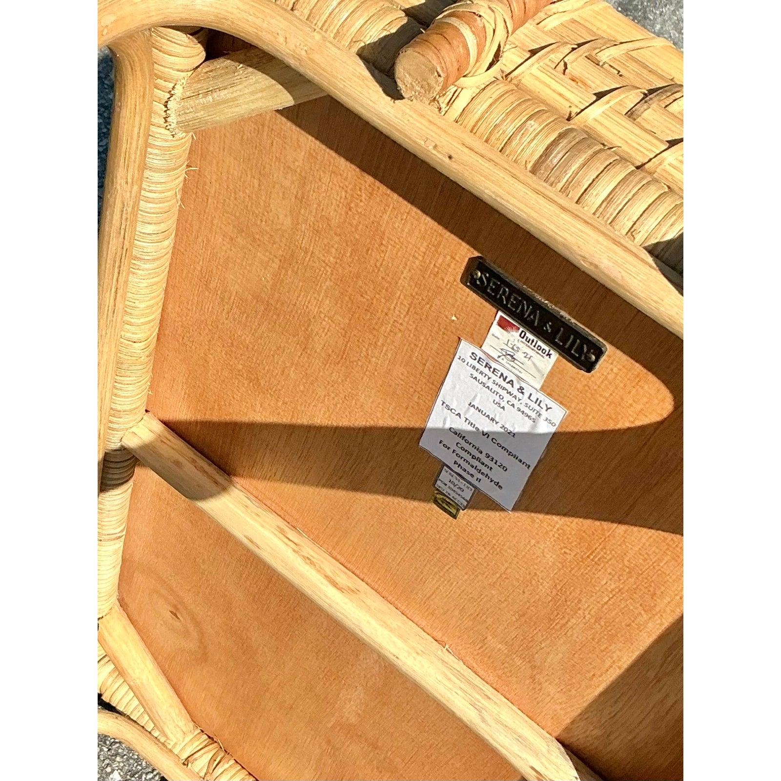 Apportez une touche de charme côtier à votre maison avec cet exquis chariot de bar en rotin vintage de Serena & Lily. Tissé à la main avec un savoir-faire complexe, ce chariot à deux niveaux présente un design en osier naturel avec des détails