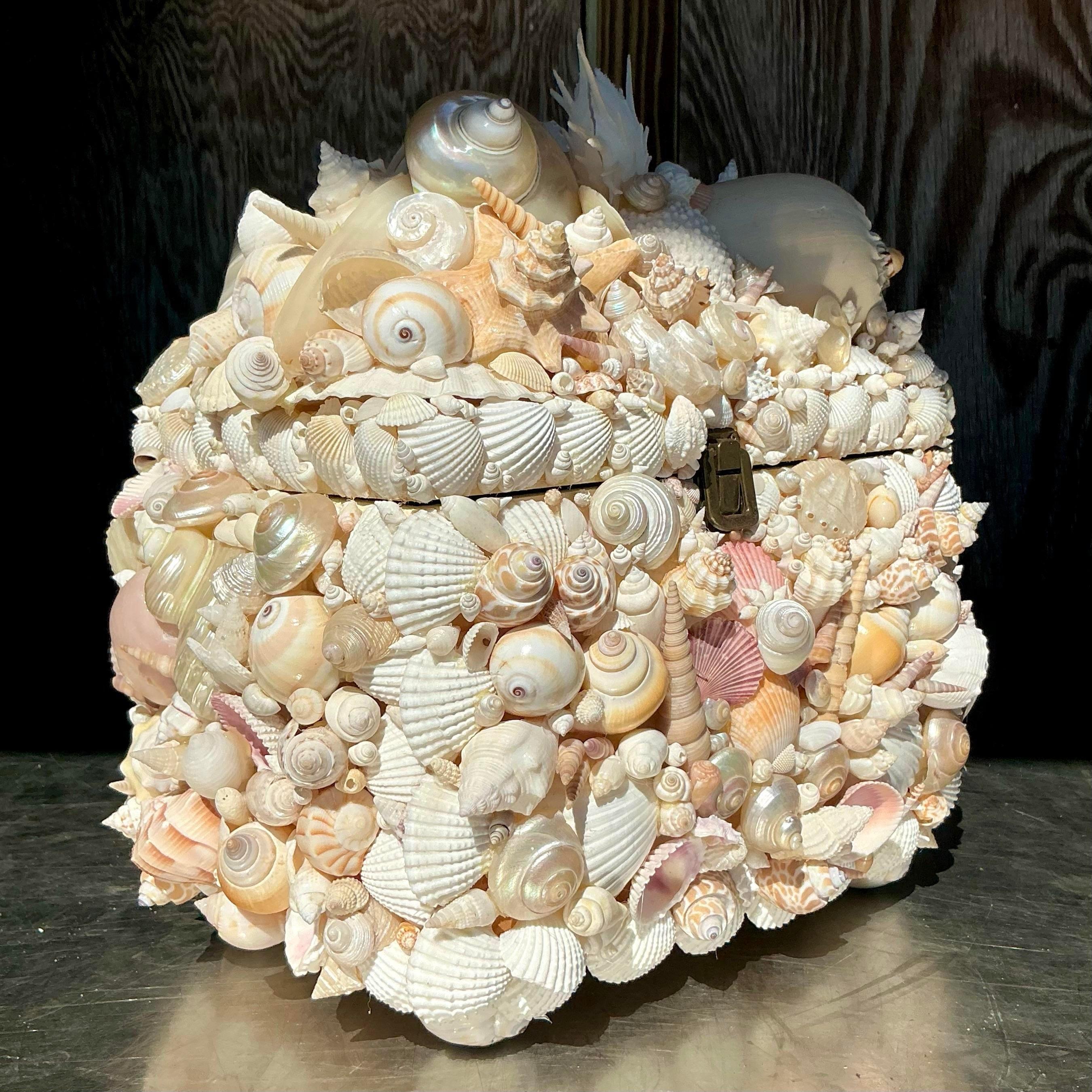 Questa scatola costiera vintage è splendidamente incrostata con una serie di conchiglie naturali, creando una splendida superficie strutturata che cattura l'essenza del fascino della spiaggia. Perfetta come elemento decorativo o come portaoggetti,