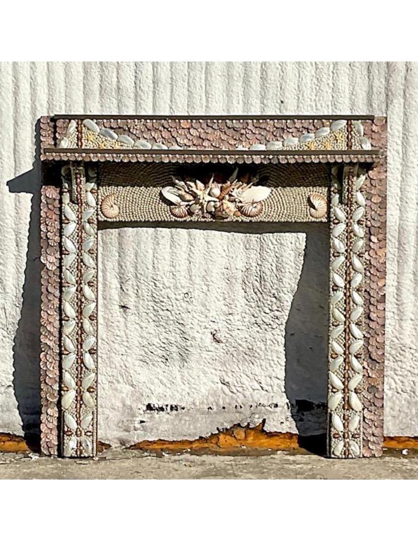 An extraordinary vintage Coastal fireplace surround. A chic hand encrusted frame with incredible attention to detail. Acquired from a Palm Beach estate.