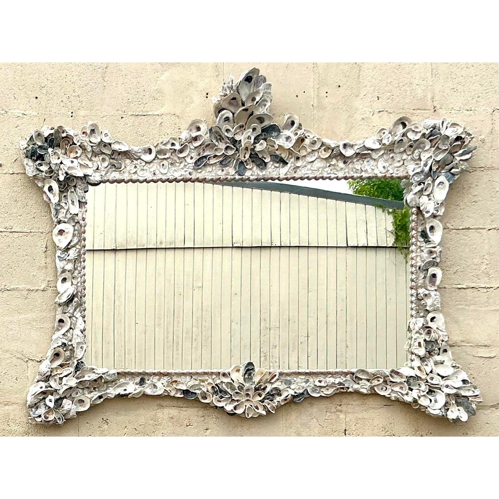 Plongez votre espace dans l'esprit tranquille de la côte avec ce magnifique miroir vintage incrusté de coquillages. Exemple étonnant de dévouement artisanal, son cadre généreux est méticuleusement orné d'un ensemble captivant de coquillages