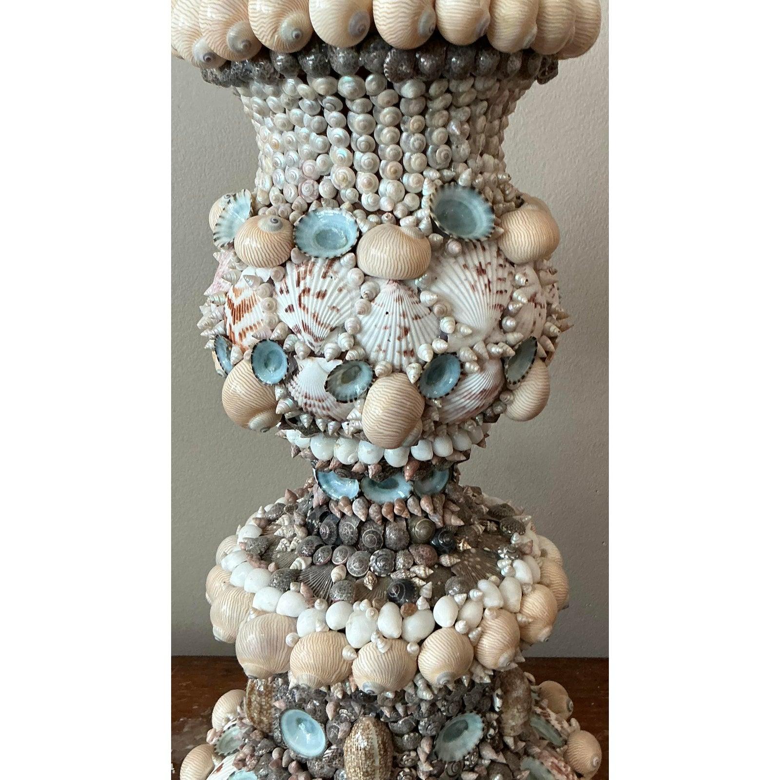Evoke the serene beauty of the seaside with this stunning vintage shell-encrusted lamp. Meticulously adorned with a diverse array of natural shells, from delicate spirals to shimmering abalone pieces, this lamp is a true testament to coastal