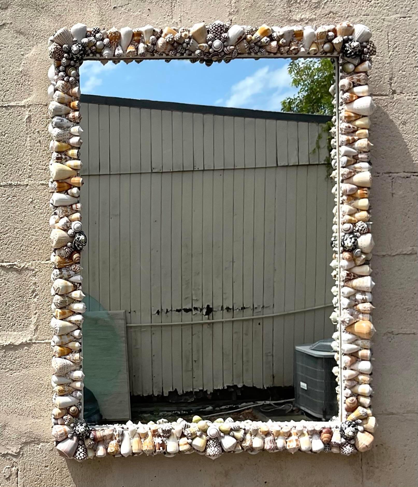 Bring coastal allure to your space with this vintage shell-encrusted mirror. American-crafted with a nod to seaside beauty, this mirror showcases natural shells in a captivating design, adding a touch of beach-inspired elegance to any room.