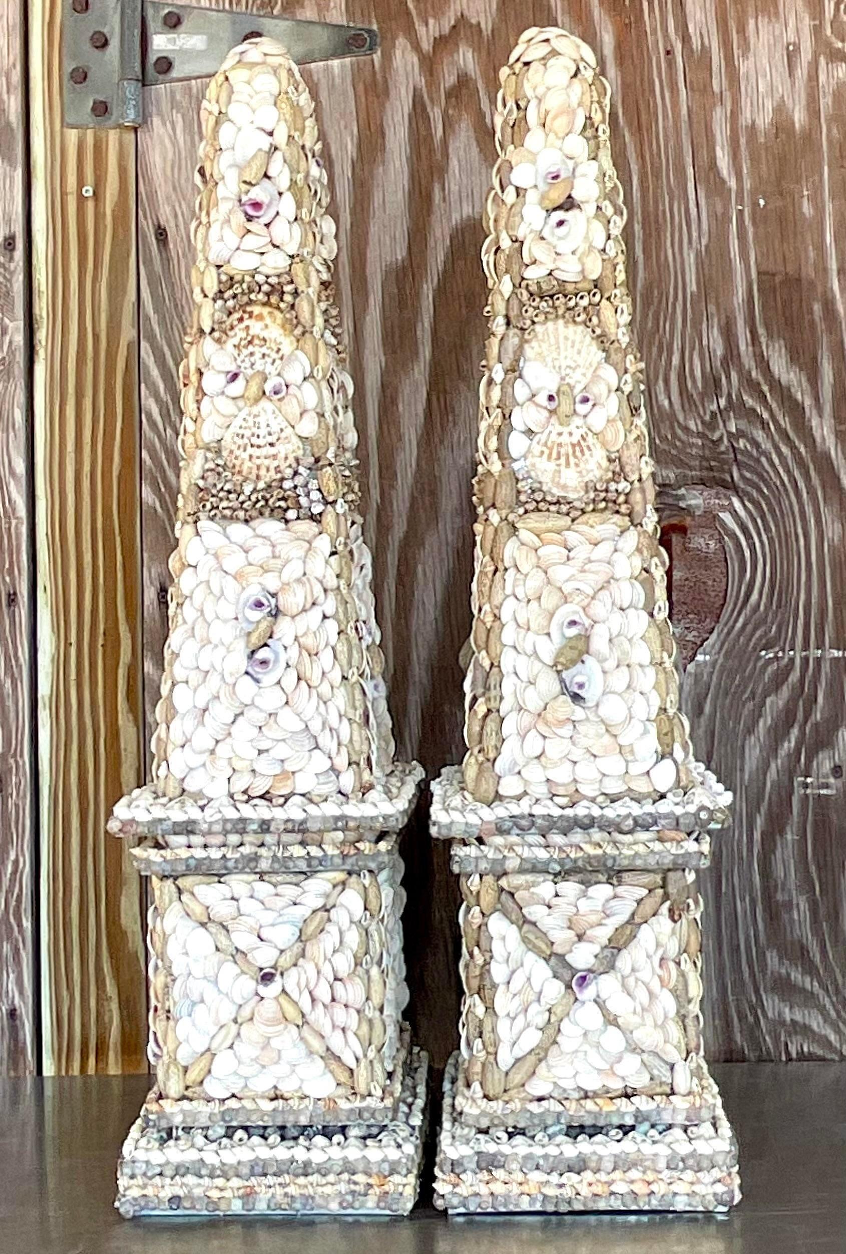 A fabulous pair of vintage Coastal obelisks. Chic Shell encrusted design placed by hand. Acquired from a Palm Beach estate.