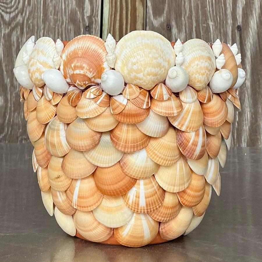 Bring coastal charm into your home with this vintage shell-encrusted planter. Adorned with an array of delicate shells, this planter showcases natural seaside beauty, perfect for enhancing the look of any indoor or outdoor space. Its sturdy design