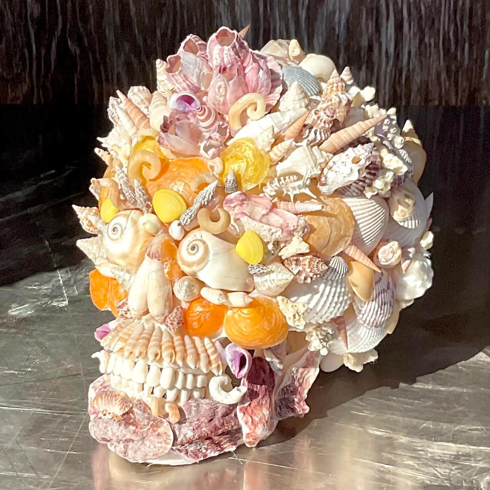 A fantastic vintage coastal hand placed shell encrusted skull. A fabulous selection of brightly colored shells in the most clever design. Acquired from a Palm Beach estate.