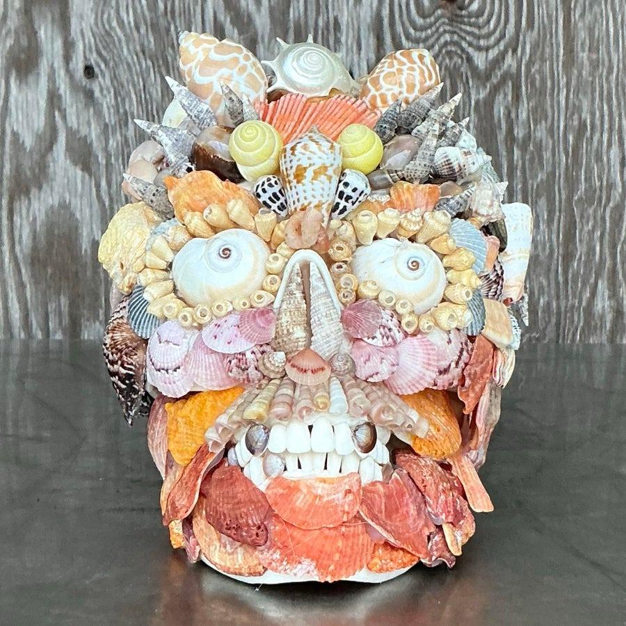 Celebra l'arte dell'oceano con questo straordinario teschio vintage tempestato di conchiglie. Ogni dettaglio intricato è realizzato con una varietà di conchiglie colorate, creando un pezzo unico che cattura la bellezza della vita marina. Questo