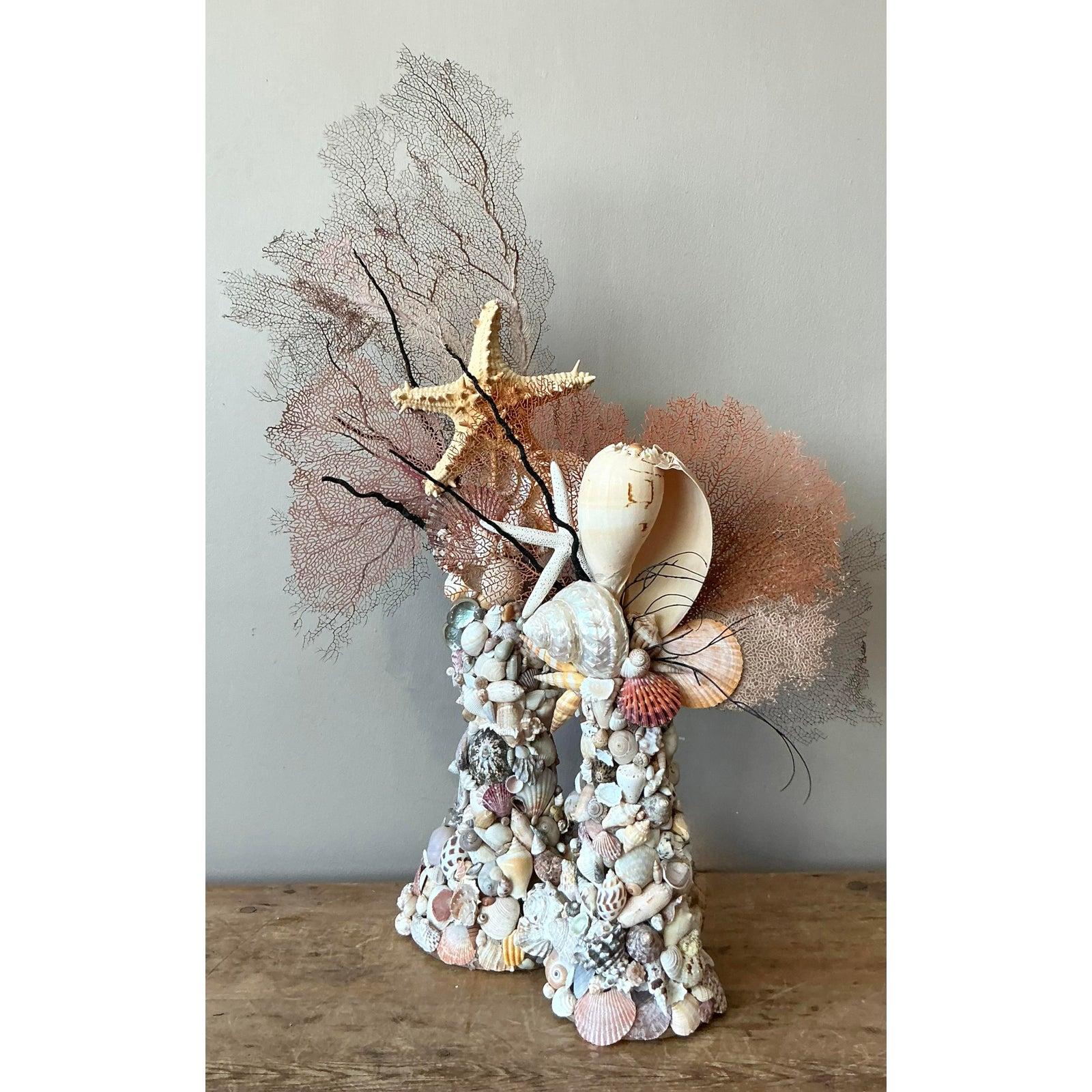 Plongez votre intérieur dans le romantisme de la mer avec cette magnifique sculpture obélisque vintage incrustée de coquillages. Véritable témoignage de l'art côtier et du design organique, ce totem est méticuleusement orné d'une collection dense et
