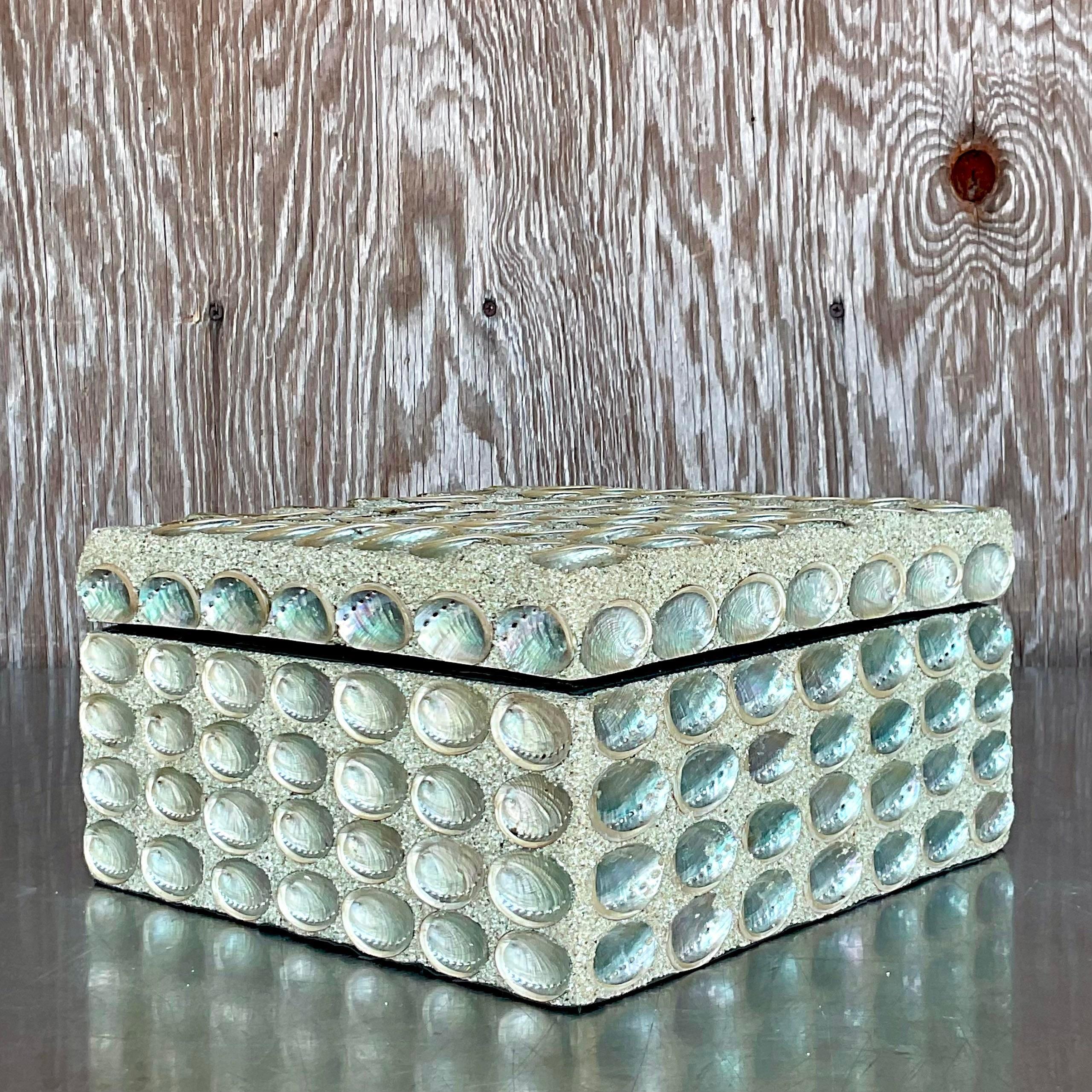 A gorgeous vintage silver decoration box with shells encrusted on the exterior. It is a great and useful addition to a coastal aesthetic living space. Acquired at a Palm Beach estate.