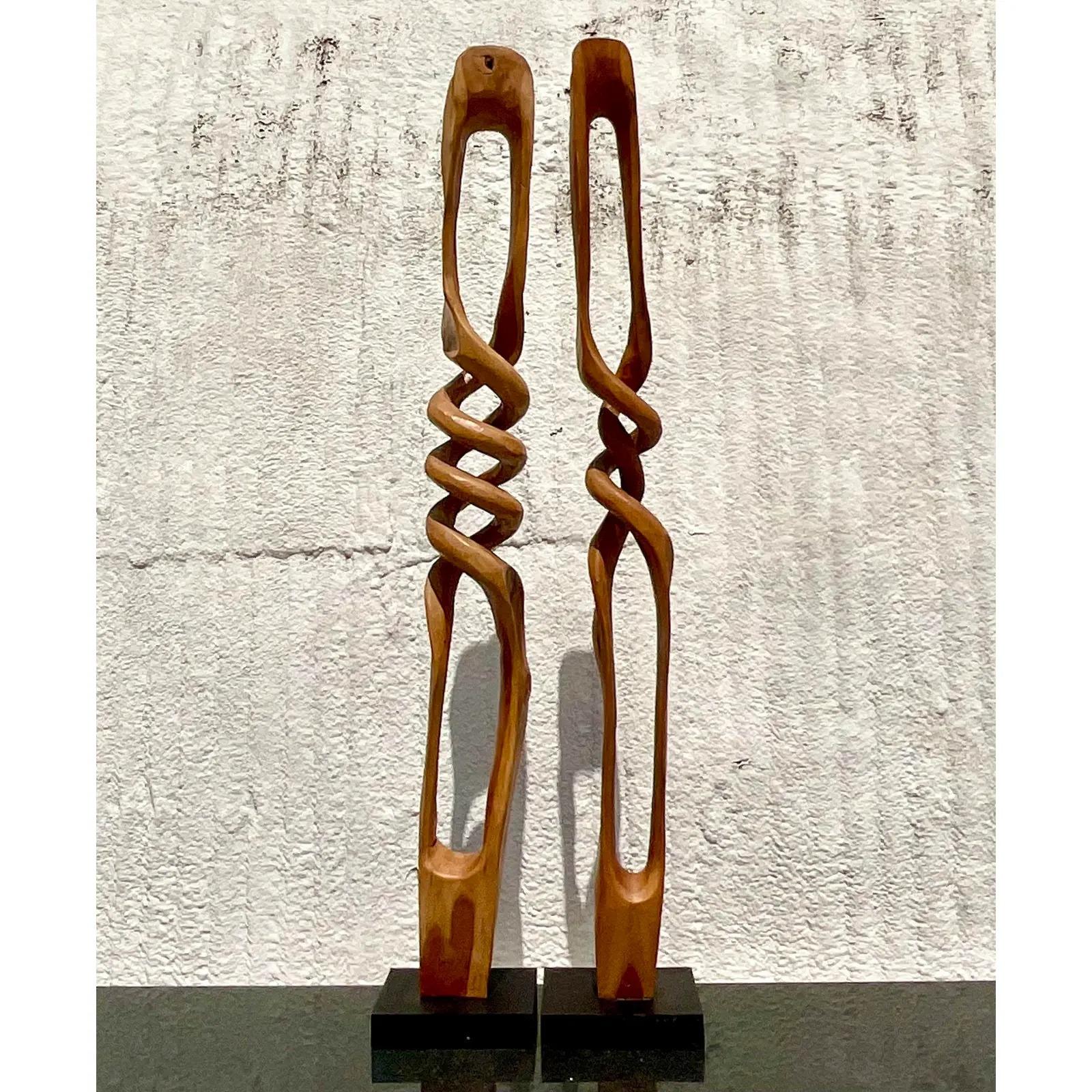 Fantastic pair of vintage teak sculptures. Tall and impressive and carved from a single piece of wood. Acquired from a Palm Beach estate.