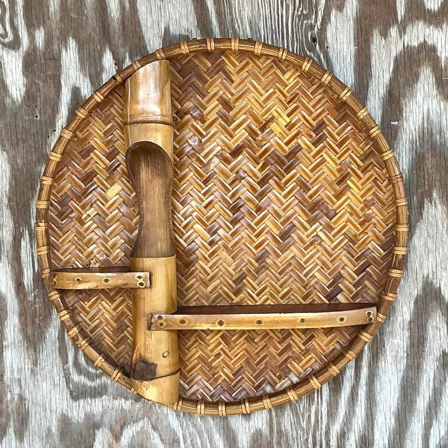 Infondi nel tuo spazio il fascino della costa con questa deliziosa mensola da parete, realizzata a mano in rattan intrecciato e bambù. Il suo intricato design a intreccio di cesti e gli accenti di bambù naturale evocano un'estetica tropicale e