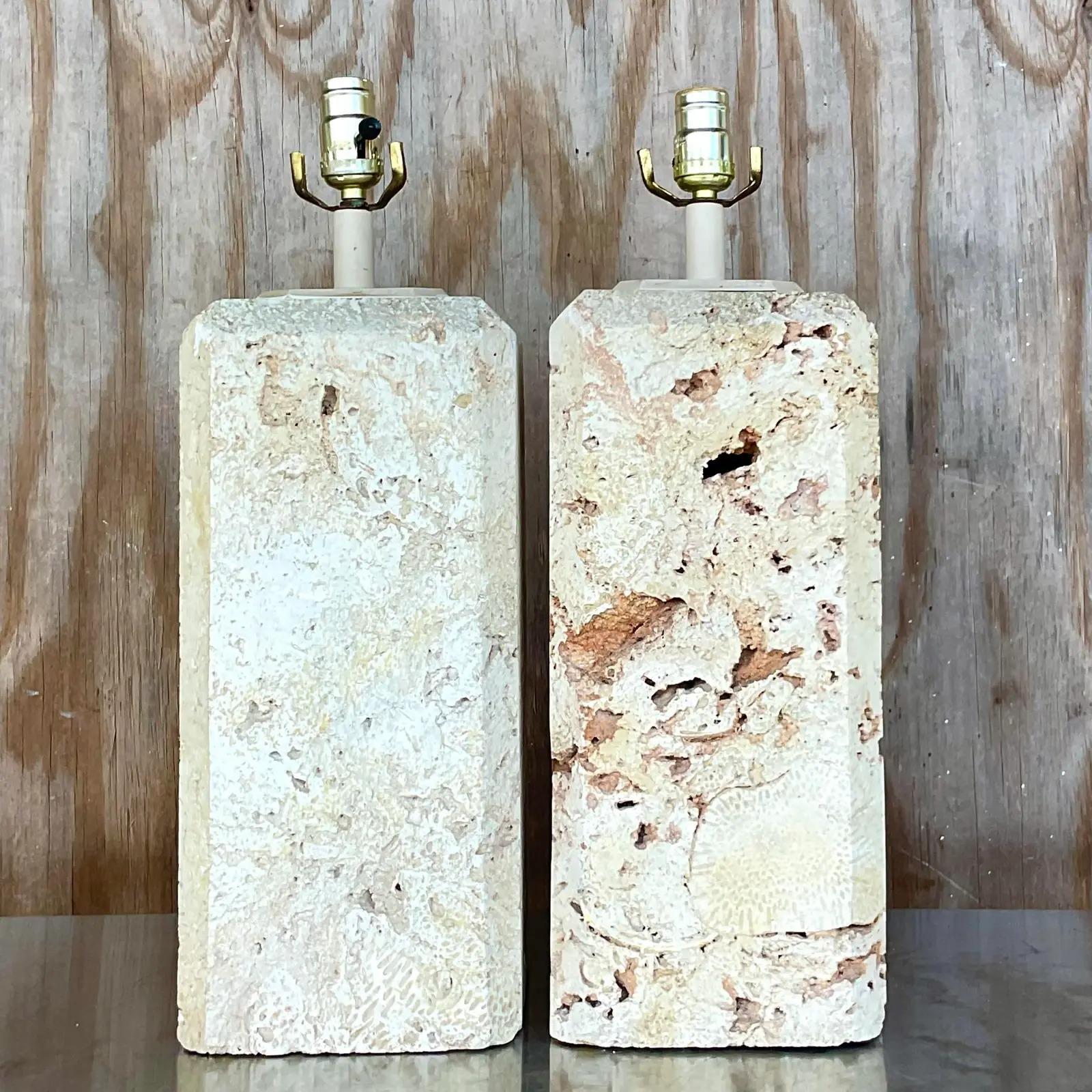 Spectacular pair of vintage Coquina stone lamps. A solid block of stone with brass hardware. Large and impressive. Acquired from a Palm Beach estate.