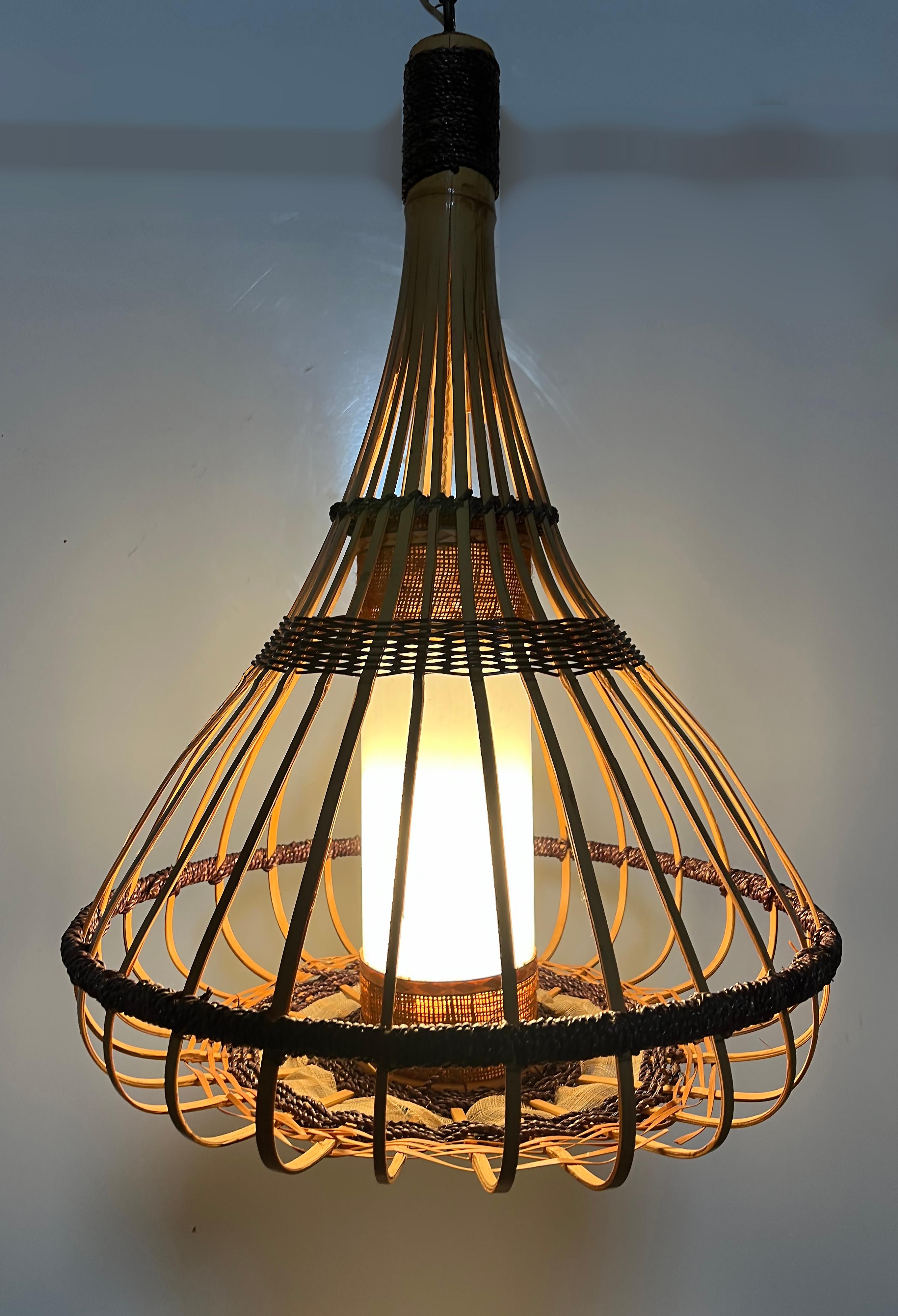 Lámpara colgante Vintage Coastal Split Rattan Reed Teardrop 

Se ofrece a la venta una lámpara colgante vintage de lágrima de ratán partido y junco con un estupendo diseño tiki costero.  La luminaria proporciona una luz encantadora desde el cilindro