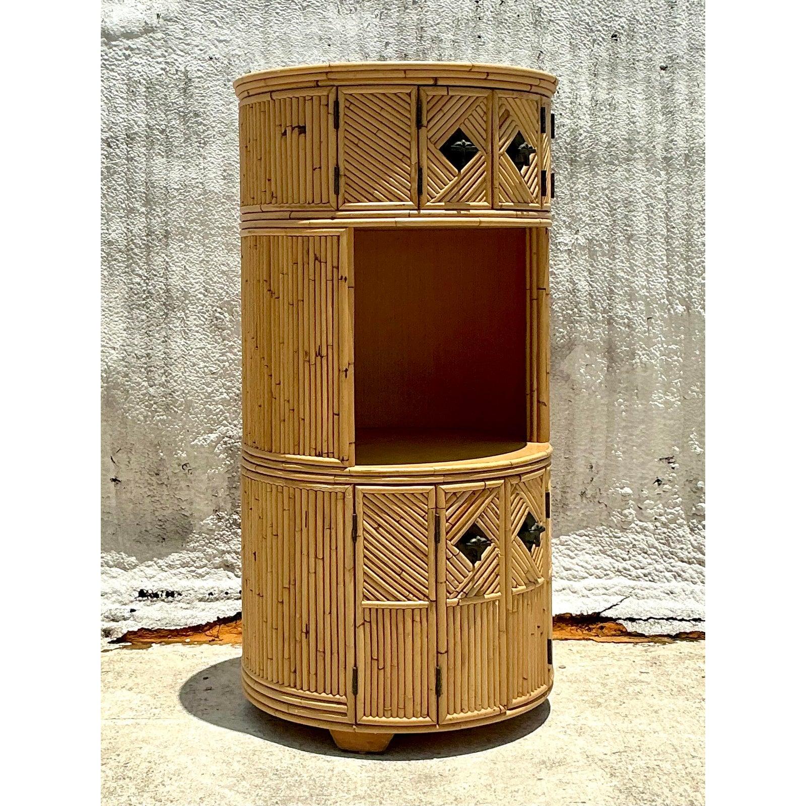 Immerse your space in the sun-drenched charm of a bygone era with this remarkable Vintage Coastal Stacked Bamboo Circular Dry Bar. A true testament to expert craftsmanship, this unique bar cabinet is meticulously constructed from natural bamboo,
