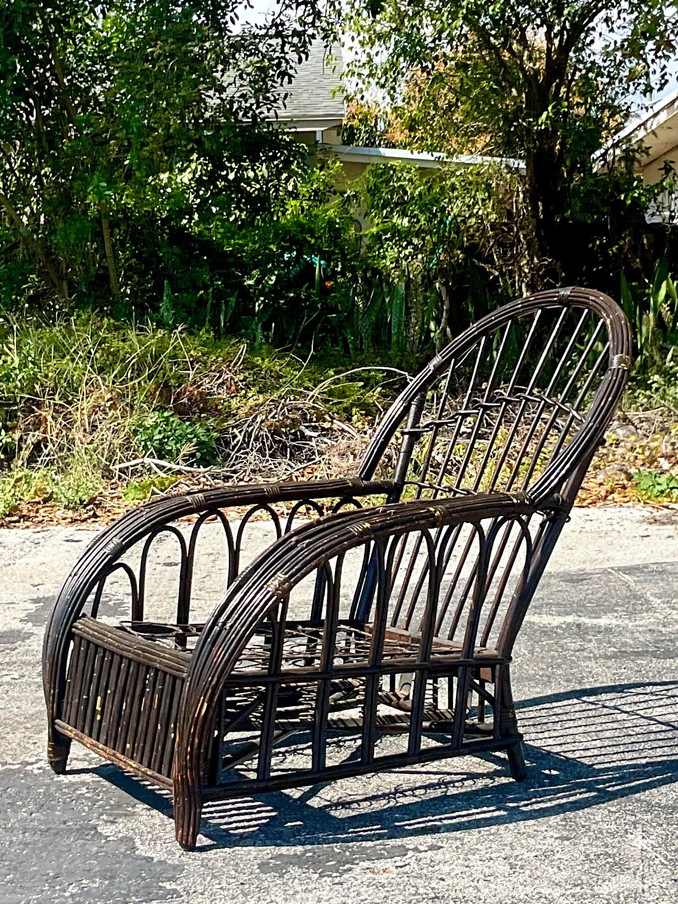 A fabulous vintage Coastal lounge chair. Beautiful stick rattan with a chic arched design. Done in the manner of Bielecky Brothers. Acquired from a Palm Beach estate.