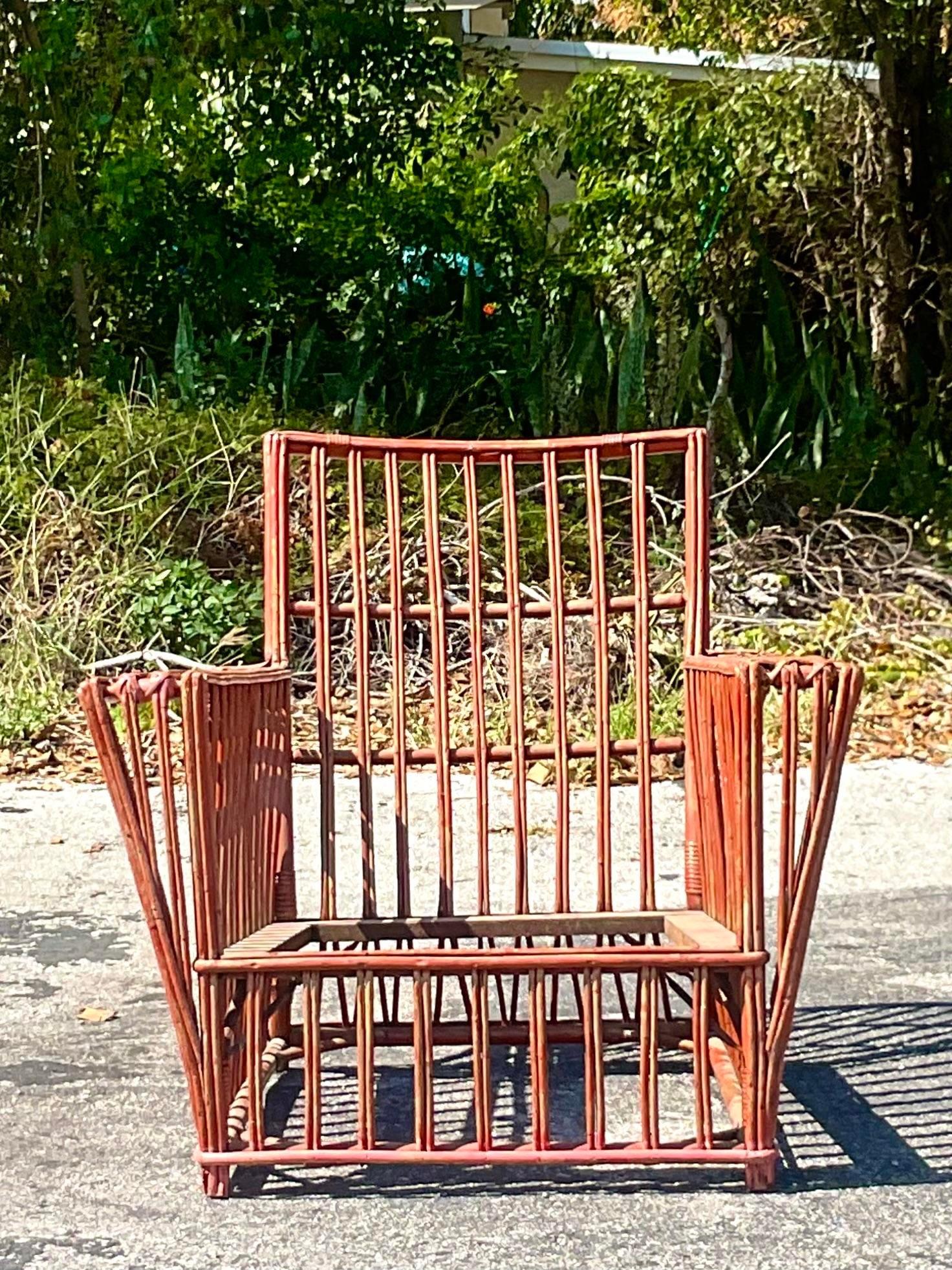 A fabulous vintage Coastal lounge chair. Beautiful stick rattan with the most beautiful painted finish. Probably painted a red that has mellowed down to a pinkish tone. Done in the manner of Bielecky Brothers. Acquired from a Palm Beach estate.