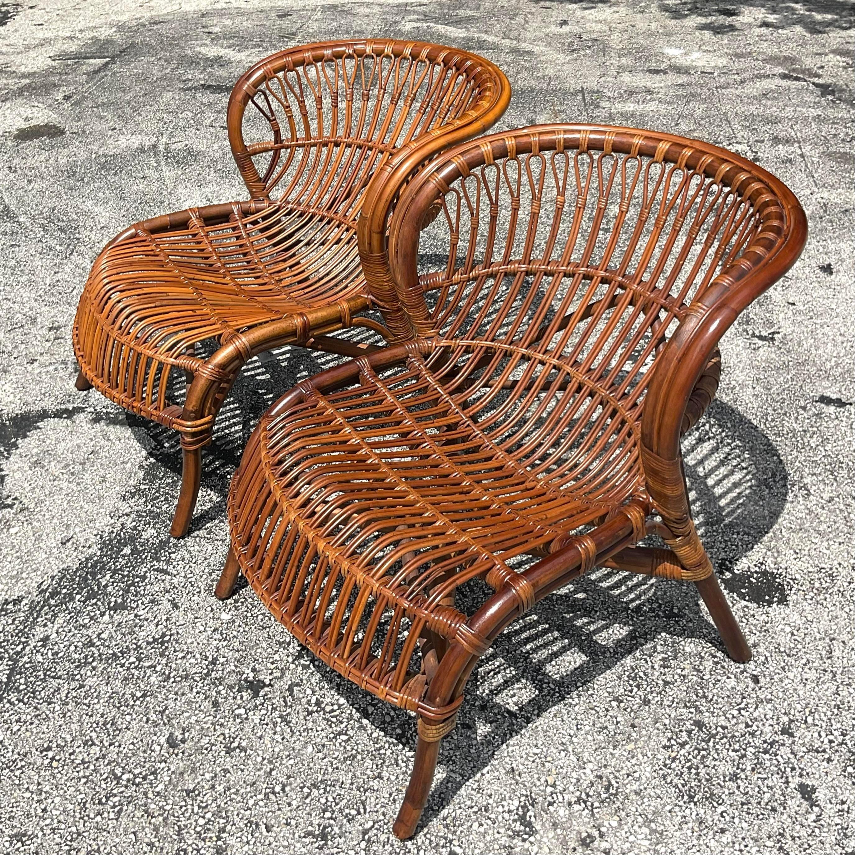 Embrace timeless American coastal charm with this pair of vintage stick rattan lounge chairs. Crafted with meticulous attention to detail, they beckon relaxation with their classic design and comfortable allure, evoking visions of lazy days by the