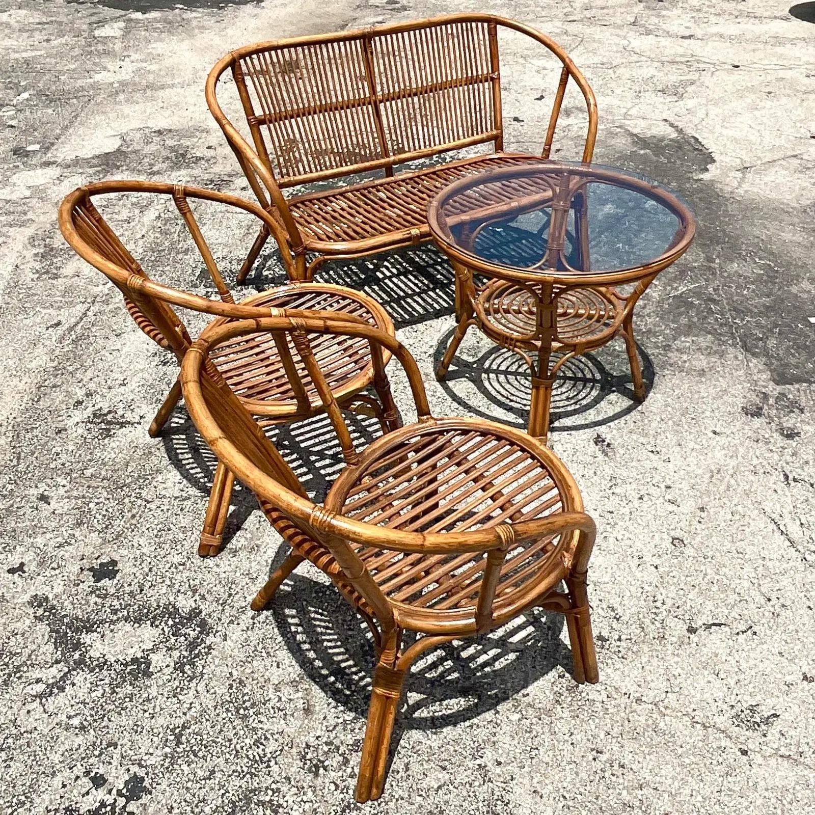 Fantastic Coastal seating set. Beautiful stick rattan set that includes a loveseat, two chairs and a coffee table. Acquired from a Palm Beach estate.

Chair dimensions- 25.25 x 18.5 x 28.75 x 14.5
Table 26 x 26 x 22.