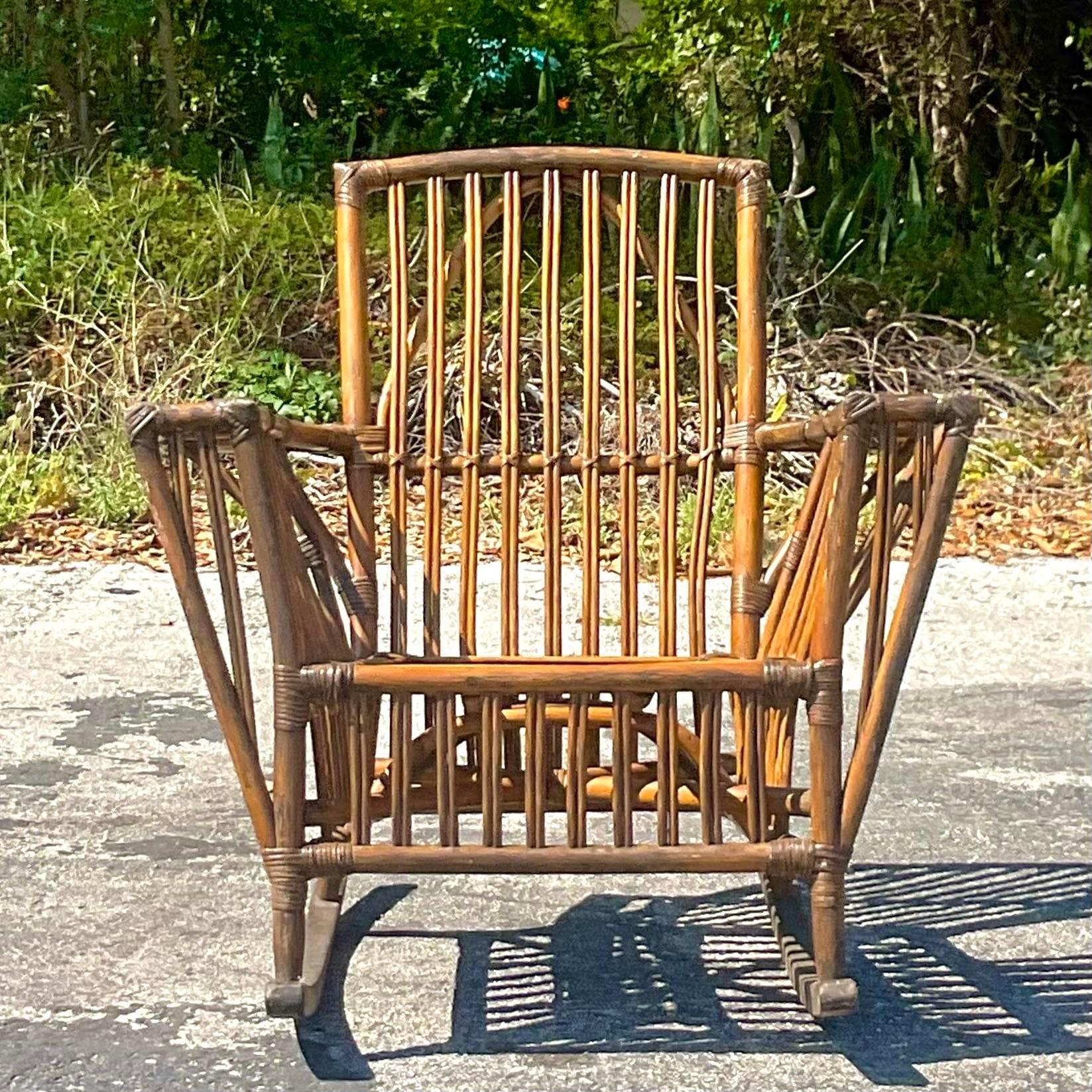 A fabulous vintage Coastal rocking chair. A chic stick rattan frame with a beautiful patina from time. Done in the manner of Bielecky Brothers. Acquired from a Palm Beach estate.