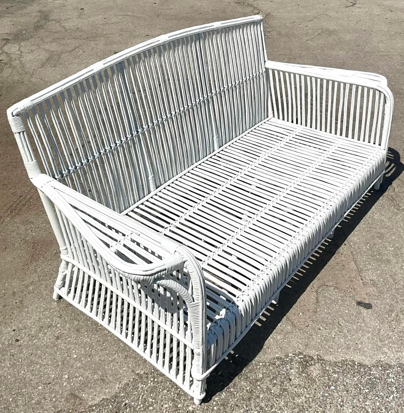 Experience timeless elegance with this Vintage Coastal Stick Rattan Sofa, inspired by the iconic designs of Bielecky. Perfectly blending coastal charm with sophisticated style, this piece features durable rattan craftsmanship, providing both comfort