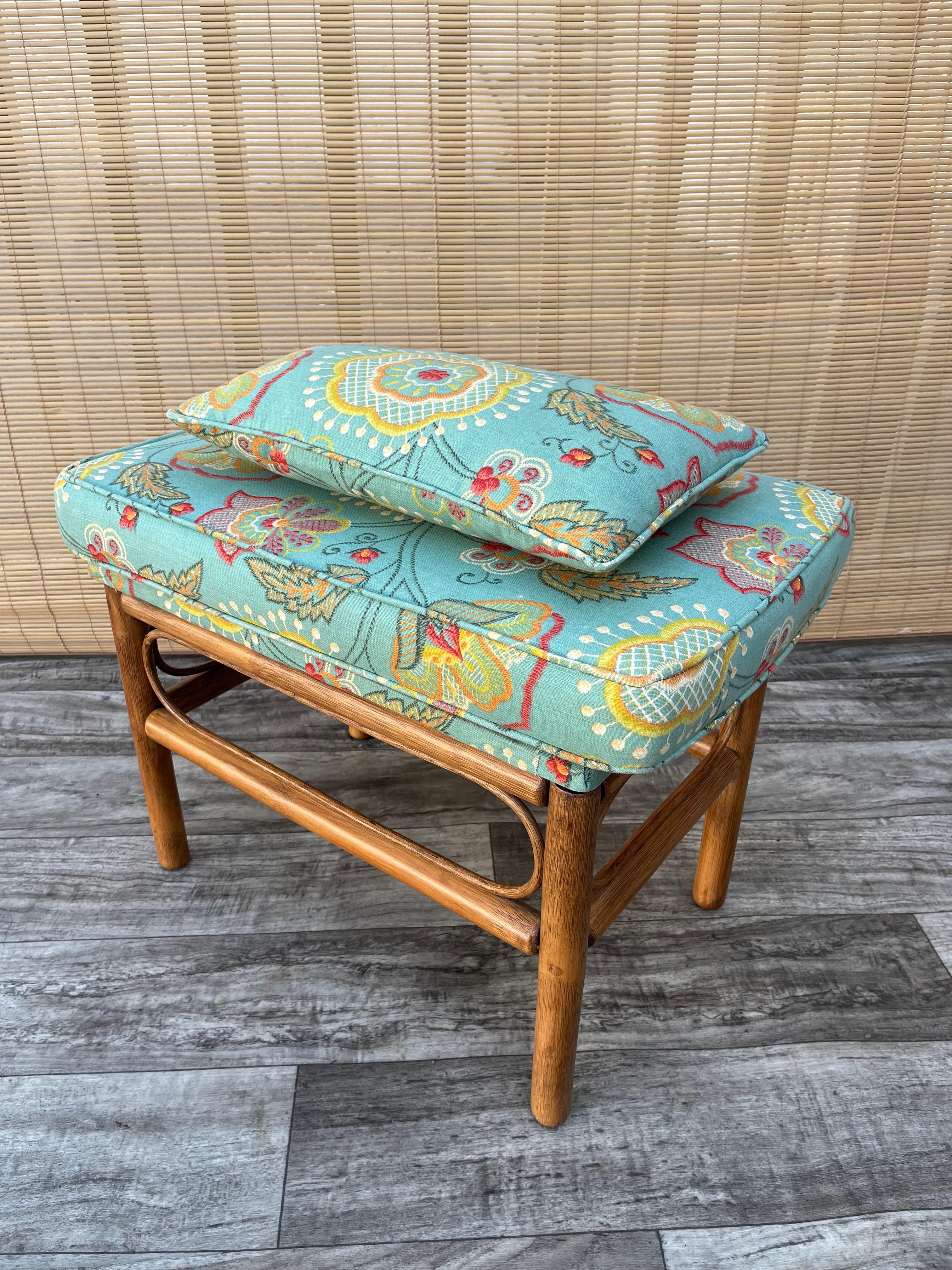 Vintage Coastal Style Boho Chic Rattan Ottoman / Bench. Circa 1960s
Features an ornate rattan frame, a removable upholstered cushion, and a matching decorative pillow.
An excellent accent piece for any room decoration. 
In excellent condition