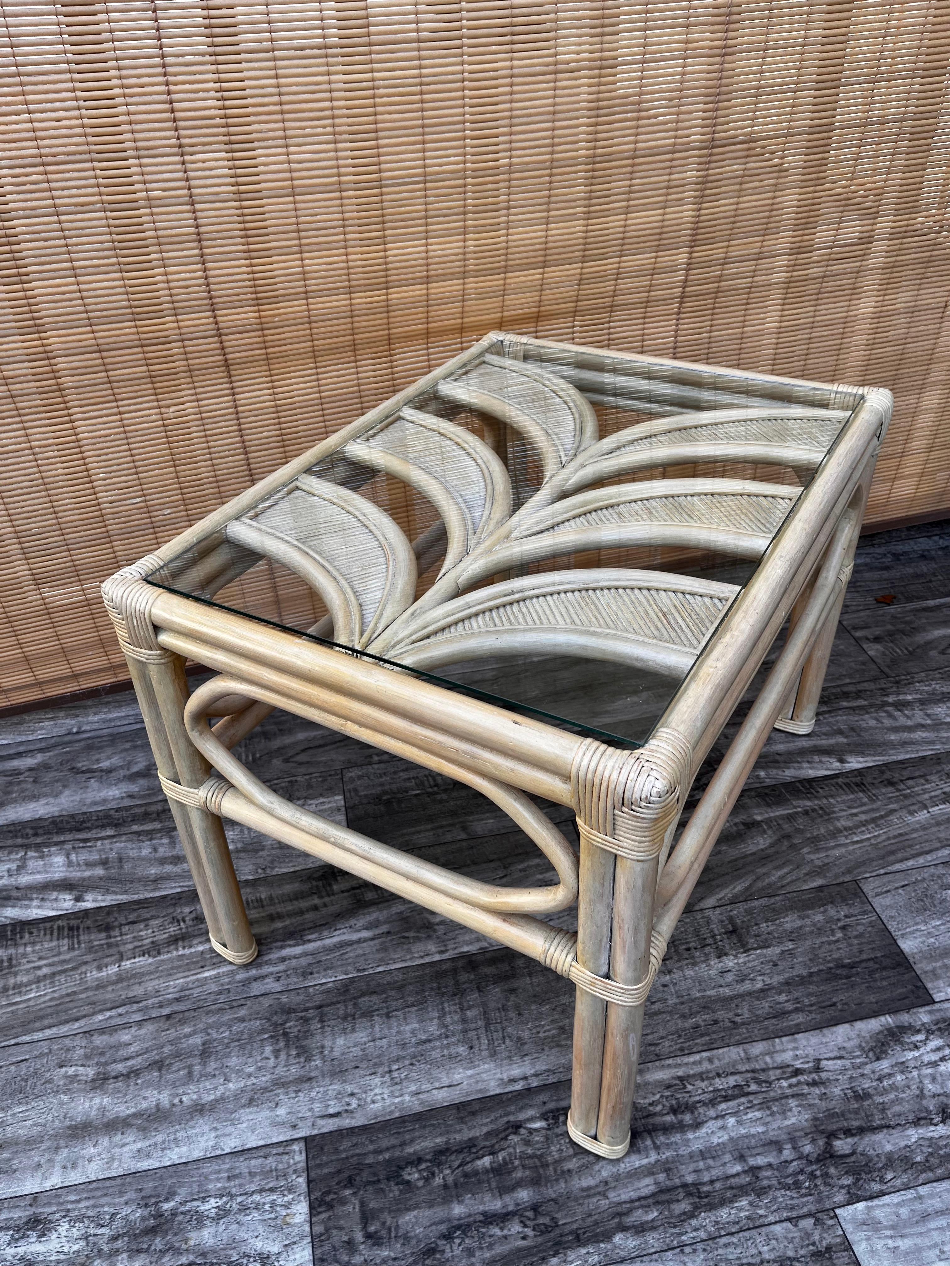 Vintage Palm Beach Regency pencil reed palm leaf glass top side table, circa 1980s. 
Features a pencil reed palm leaf motive top with a bleached rattan frame, and a removable glass top.
In excellent near mint original condition with very minor signs