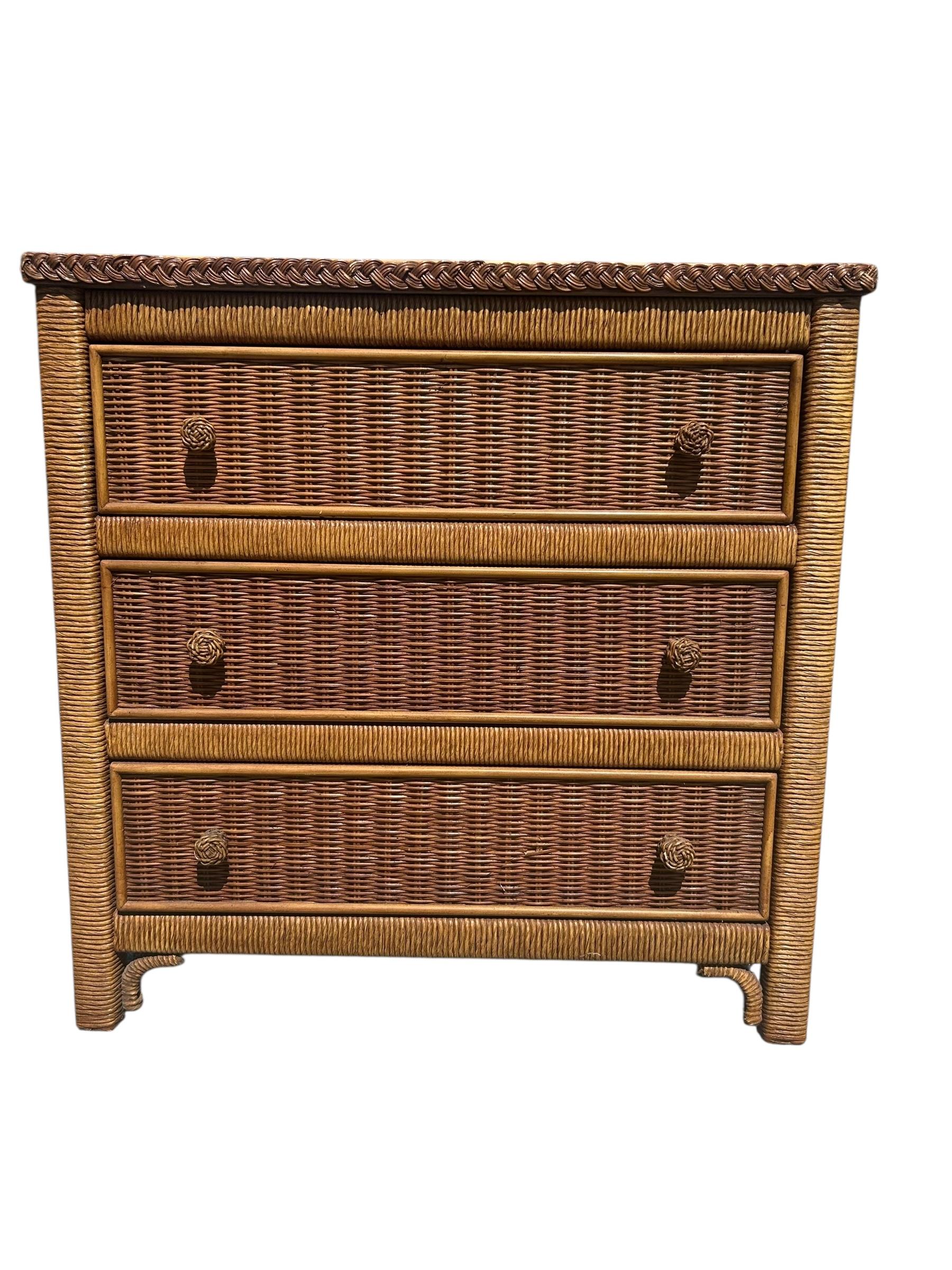 A 1980's vintage Hollywood regency / coastal style wicker nightstand by Henry Link for Lexington Furniture.  Features three spacious drawers with round woven handles, a beautiful braided wicker detail around the top edges.  In good vintage condition