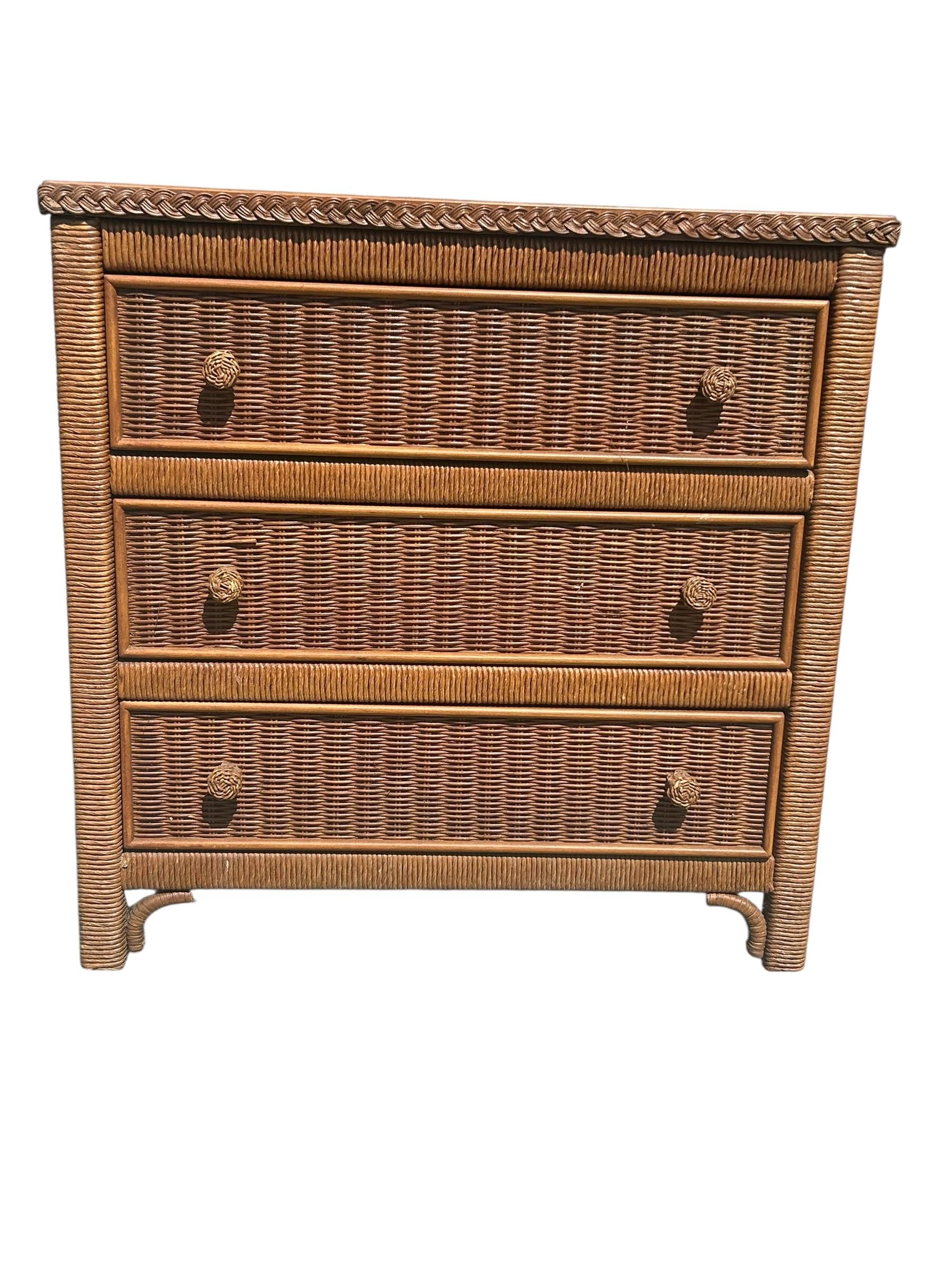 A 1980's vintage Hollywood regency / coastal style wicker nightstand by Henry Link for Lexington Furniture.  Features three spacious drawers with round woven handles, a beautiful braided wicker detail around the top edges.  In good vintage condition
