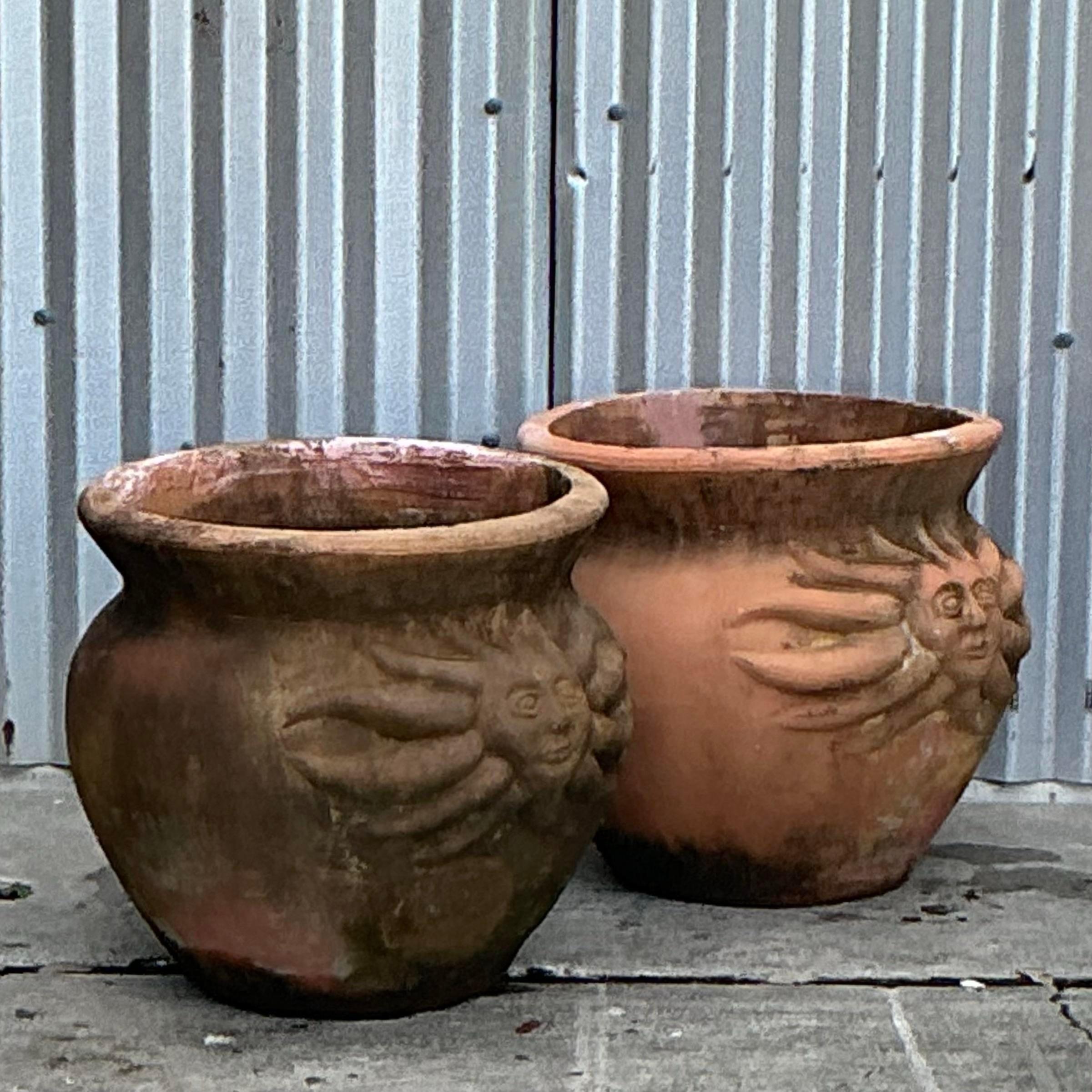 Add a breezy coastal vibe to your space with this pair of Vintage Coastal Sun Terra Cotta Planters. Each planter features a charming sun motif and warm terracotta tones, perfect for bringing a touch of seaside charm to your garden, patio, or indoor