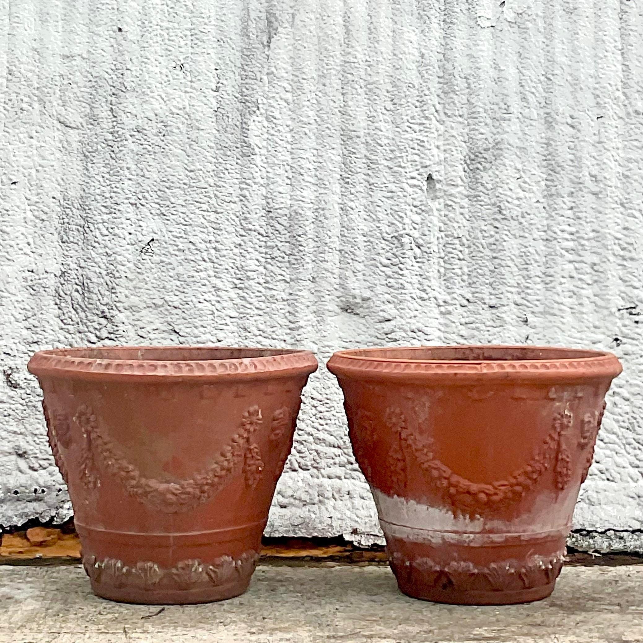 A fantastic pair of vintage Coastal planters. A chic swag garland design all around the pot. A beautiful all over patina from time. Acquired from a Palm Beach estate.
