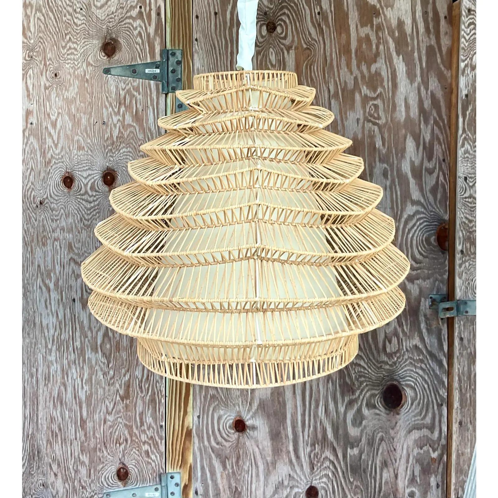 Gorgeous vintage coastal chandelier. Beautiful pale rattan in a chic and contemporary terraced design. Interior paper cone. Acquired from a Palm Beach estate.