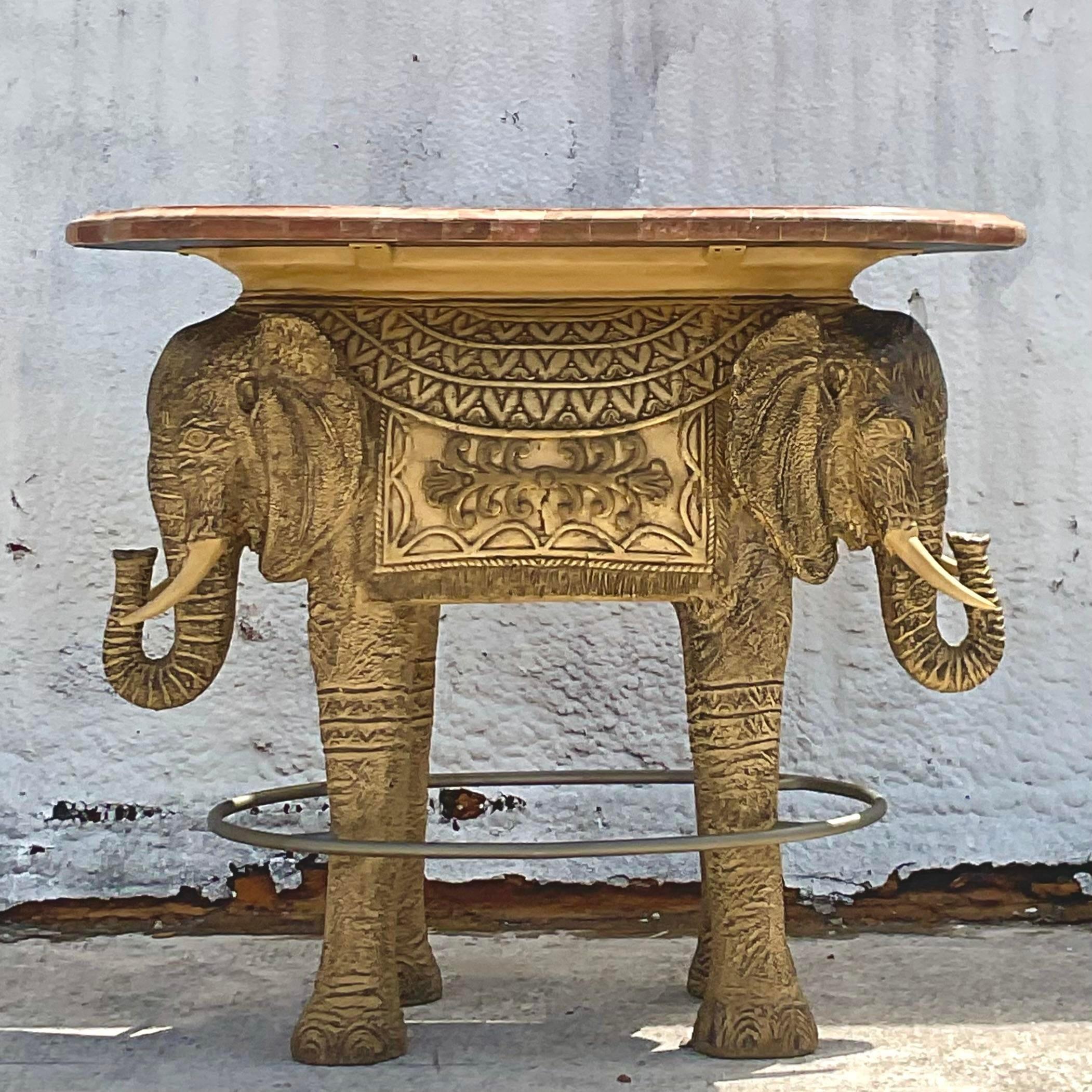 A fabulous vintage Coastal dry bar. A chic double elephant base with a tessellated stone top. A 360 running rail makes this perfect from all sides. Can be the perfect dry bar or tall dining table. You decide! Acquired from a Palm Beach estate.